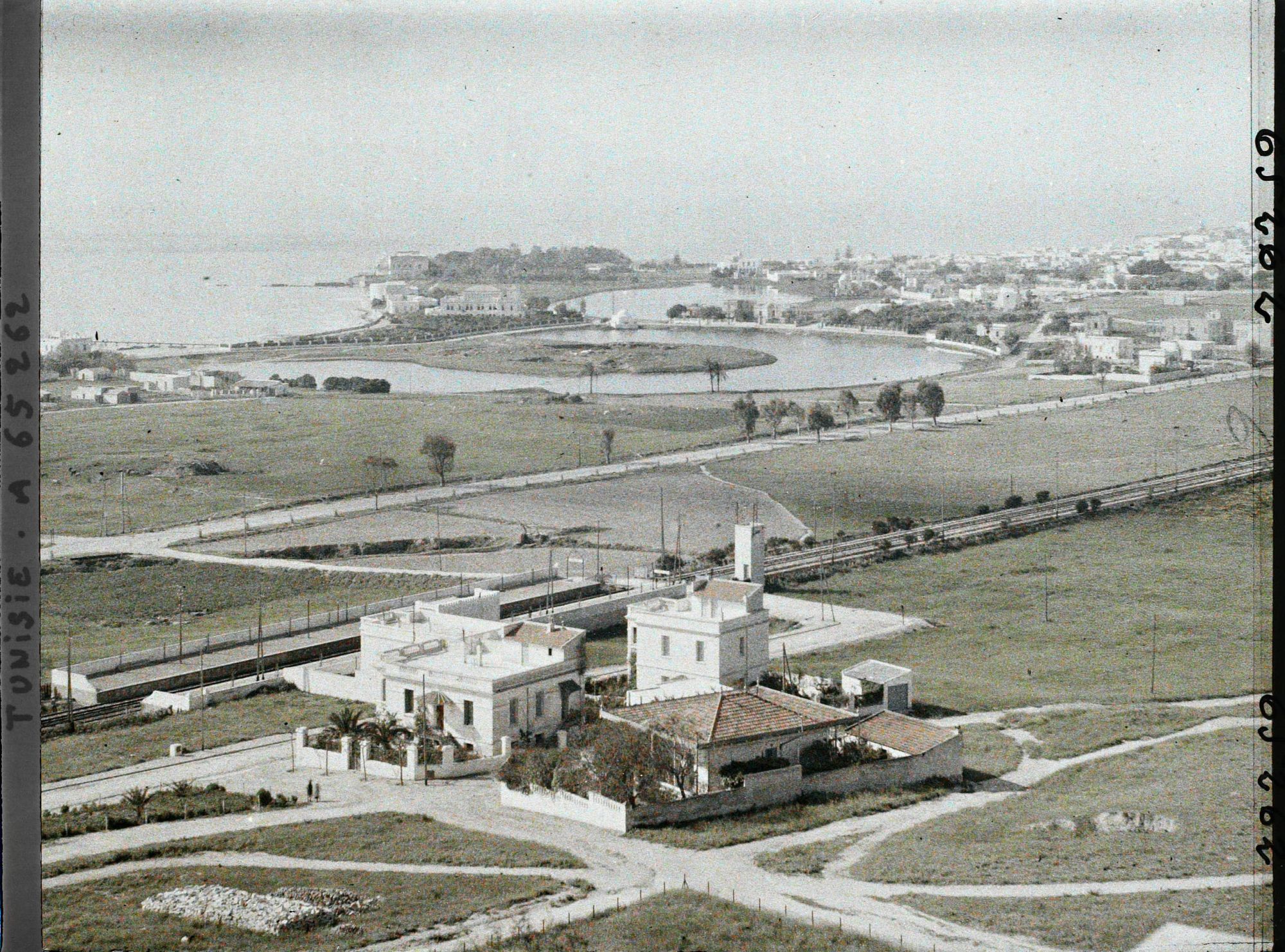 Image représentant Vue générale du double port punique prise depuis la colline de Saint-Louis qui domine Carthage, avec une station du TGM au premier plan