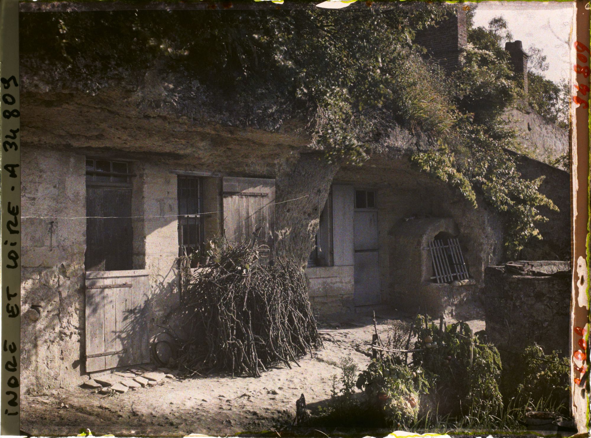 Image représentant Une maison troglodyte du Petit Coteau, à droite le puits creusé dans le roc