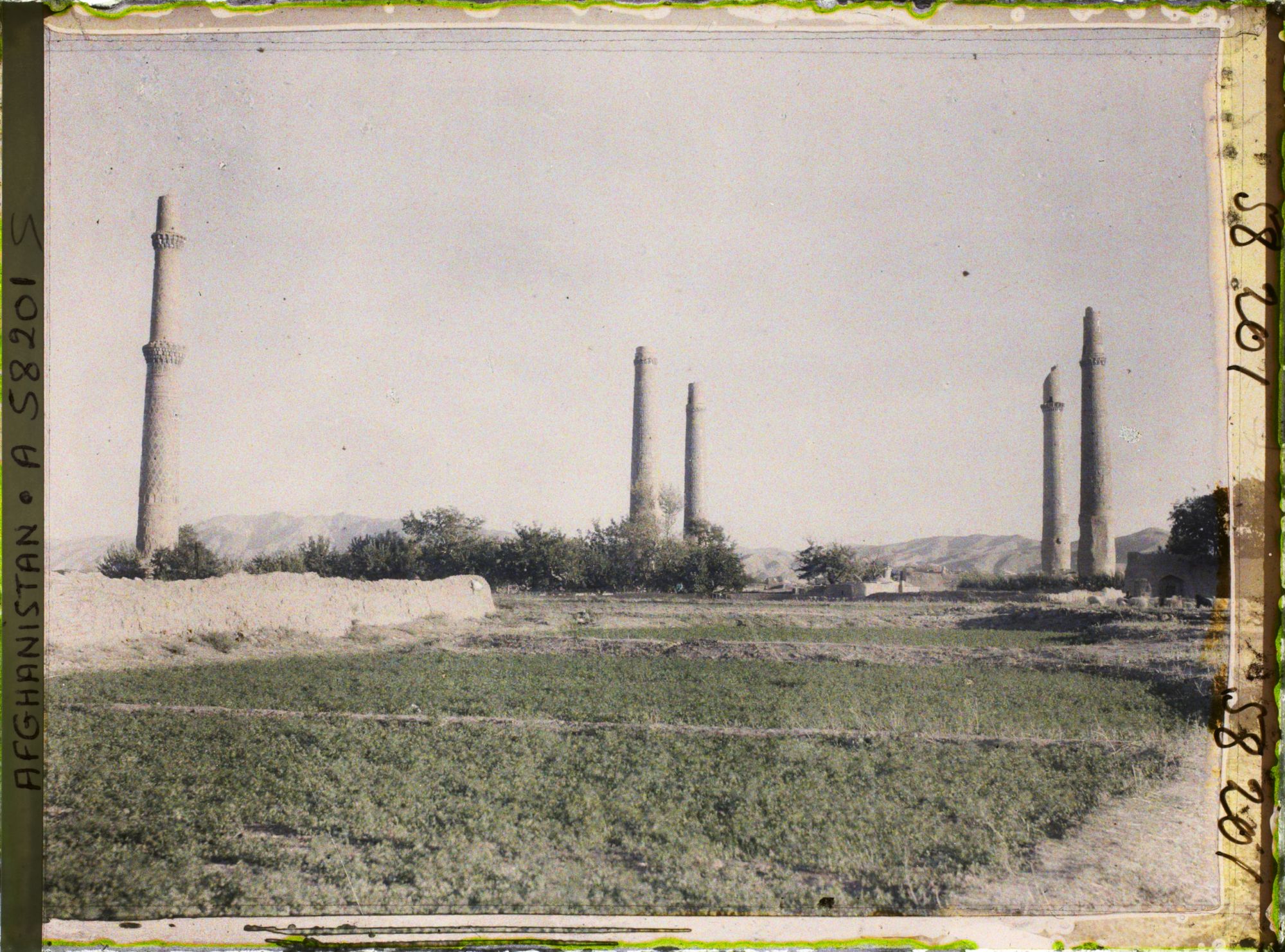 Image représentant A gauche, le seul minaret restant de l'entrée de la Madrasa de Gawhar Châd et les minarets de la Madrasa Ni' Matiye