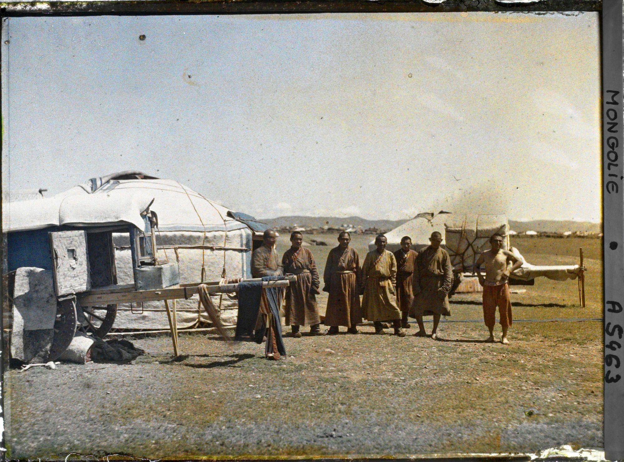 Image représentant Un groupe de lamas près de yourtes et de voitures dételées