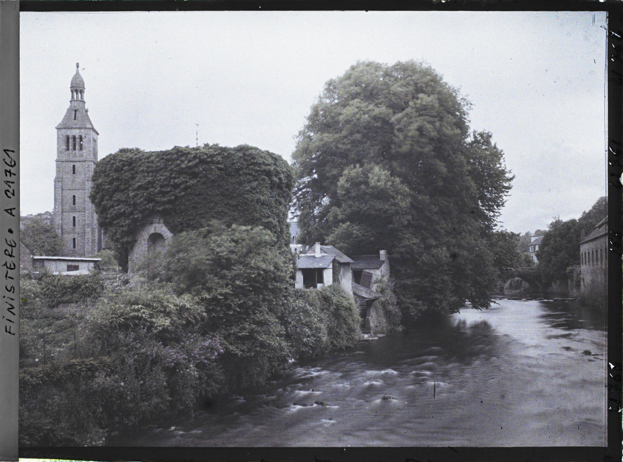 Image représentant Les bords de l'Ellé avec à gauche la tour de l'église Sainte-Croix et au premier plan l'ancien pigeonnier de l'abbaye Sainte-Croix