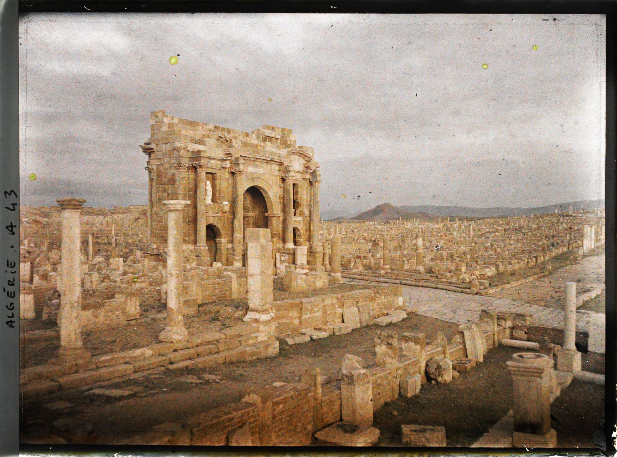 Image représentant L'arc de Trajan vu depuis le temple du Génie de la colonie