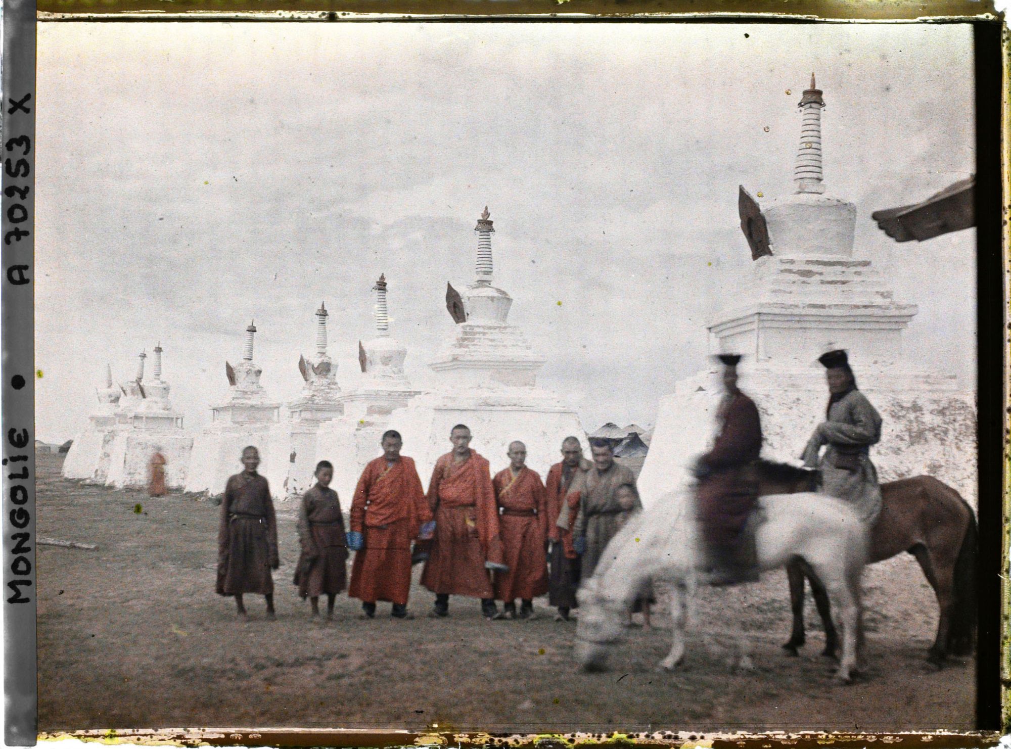 Image représentant Un groupe de lamas près du " mur " de stupa qui marque les limites de Gandan à l'ouest et au nord