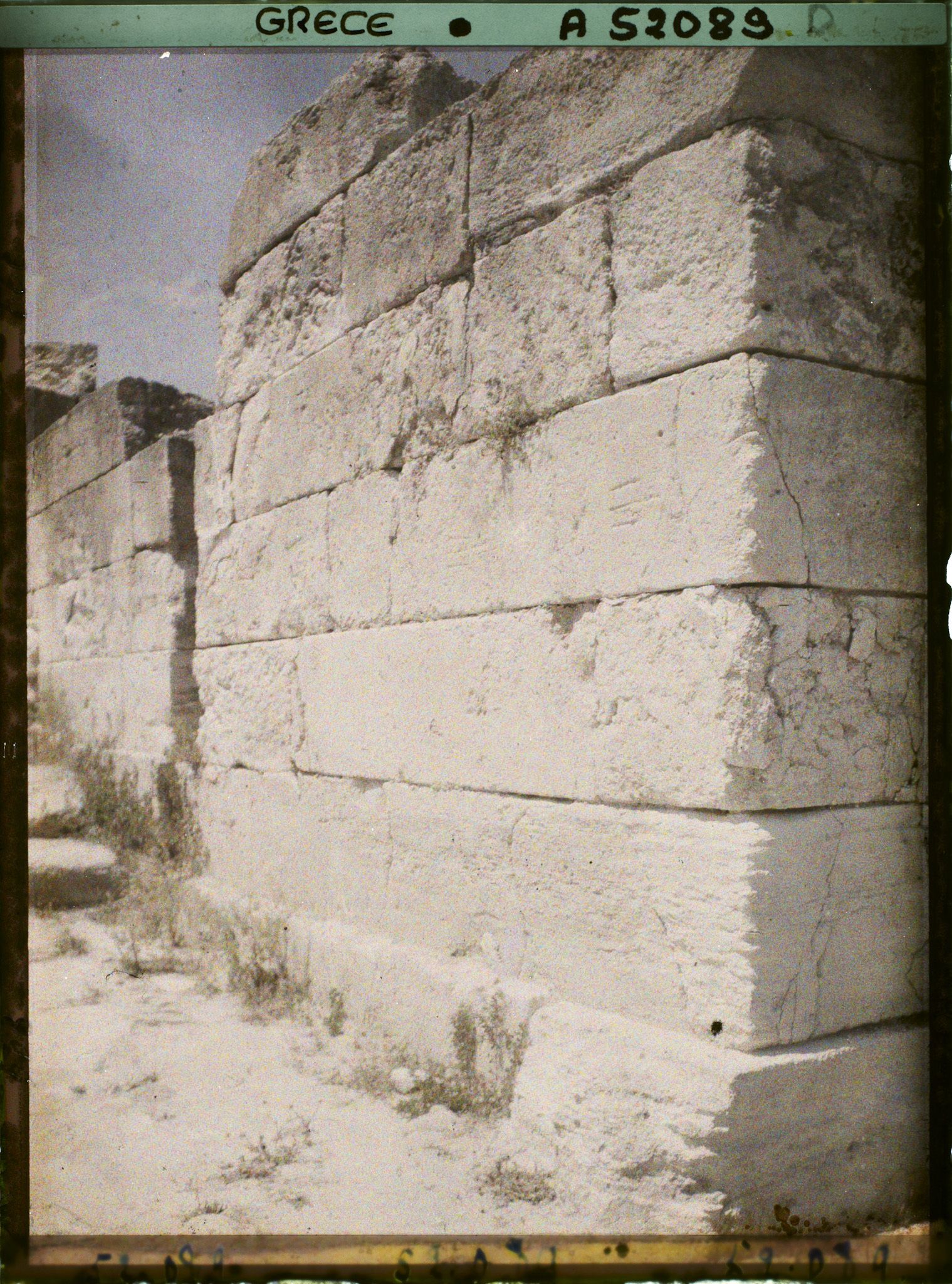 Image représentant Un mur du Palais (bordant sans doute la cour occidentale). Une pierre d'angle est gravée de tridents