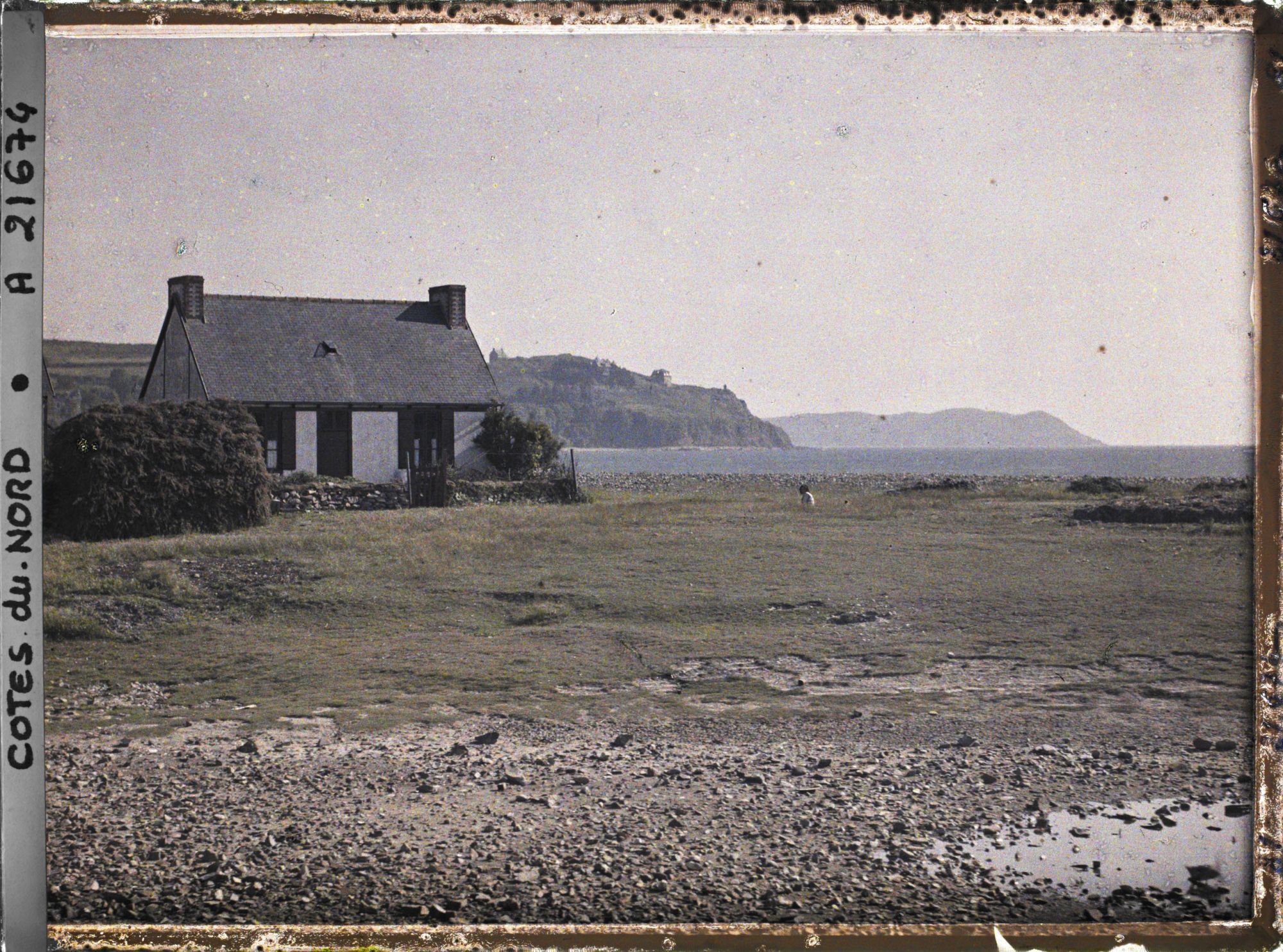 Image représentant Une maison sur la côte ; à l'arrière-plan, la pointe du Château et l'île Tomé