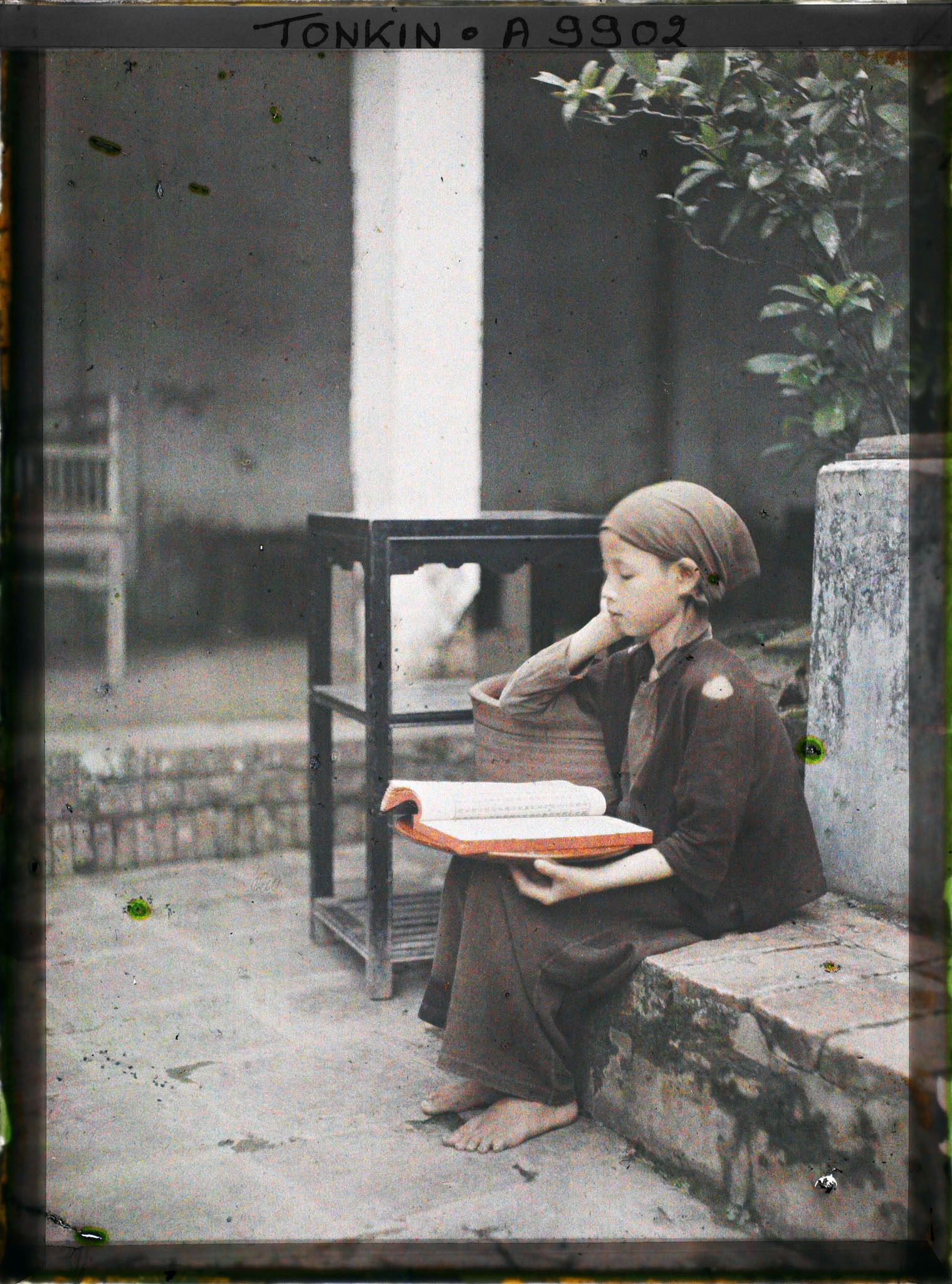 Image représentant Une toute jeune novice lisant dans la cour du temple Vien-minh