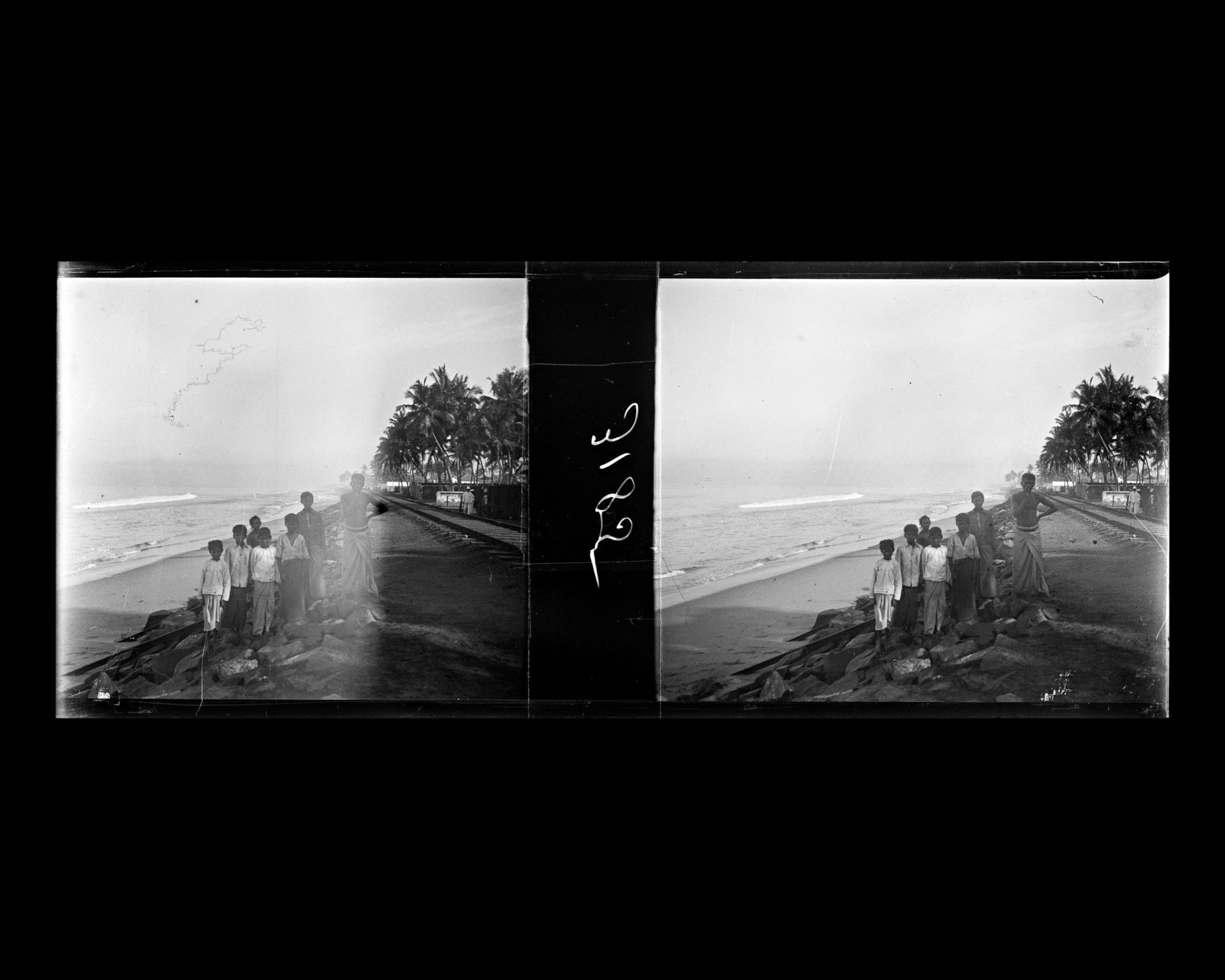 Image représentant Un groupe de Cingalais au bord de la voie ferrée qui longe la mer