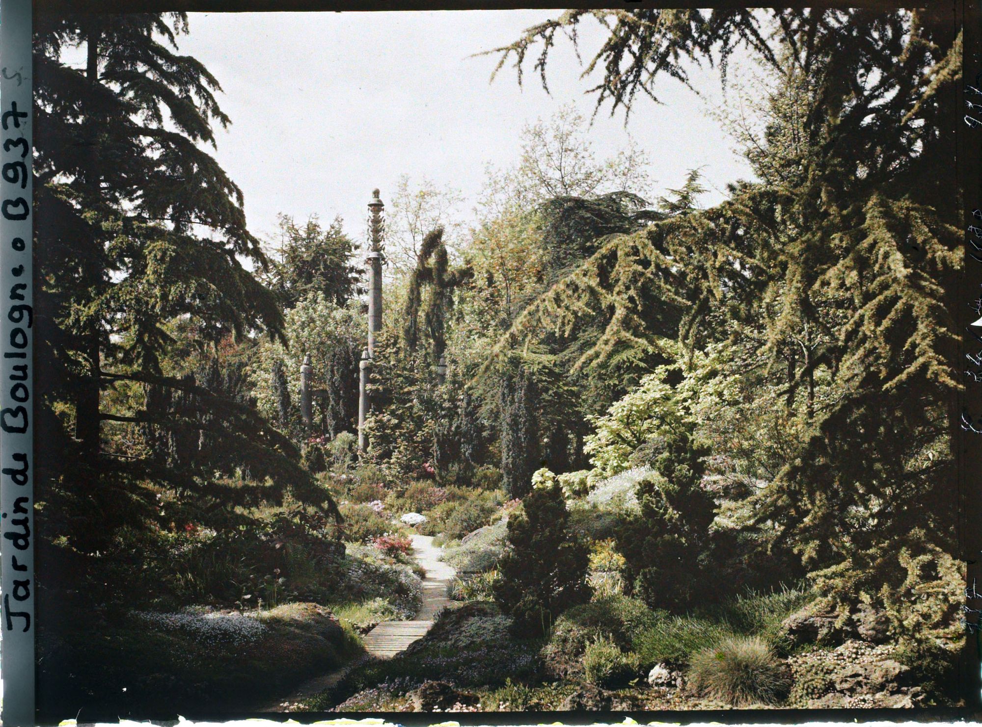 Image représentant Chemin du " sanctuaire japonais " menant au sorinto et rocaille fleurie ponctuée de conifères
