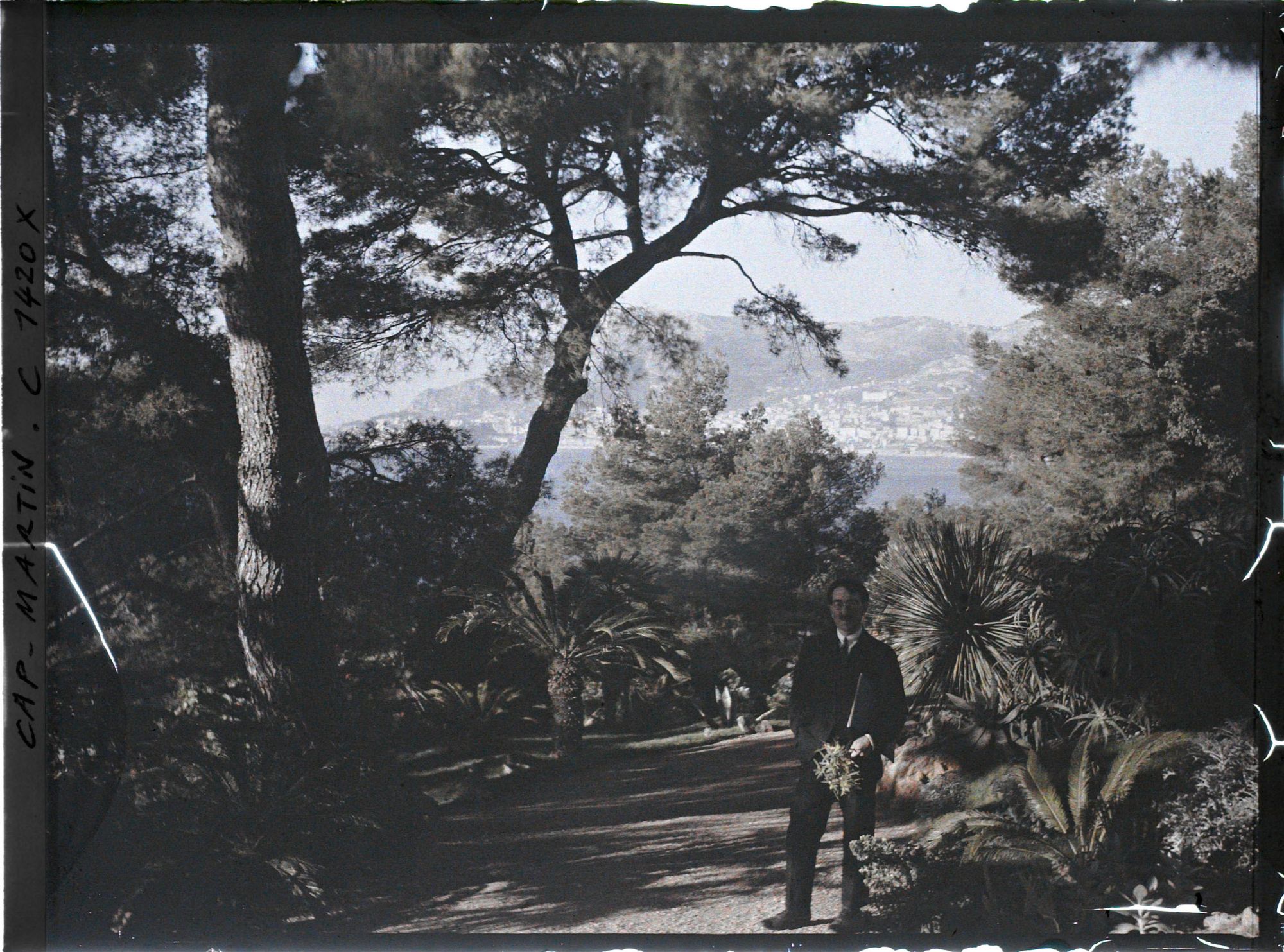 Image représentant Mathurin Méheut tenant un bouquet, dans le jardin de la villa Miramar