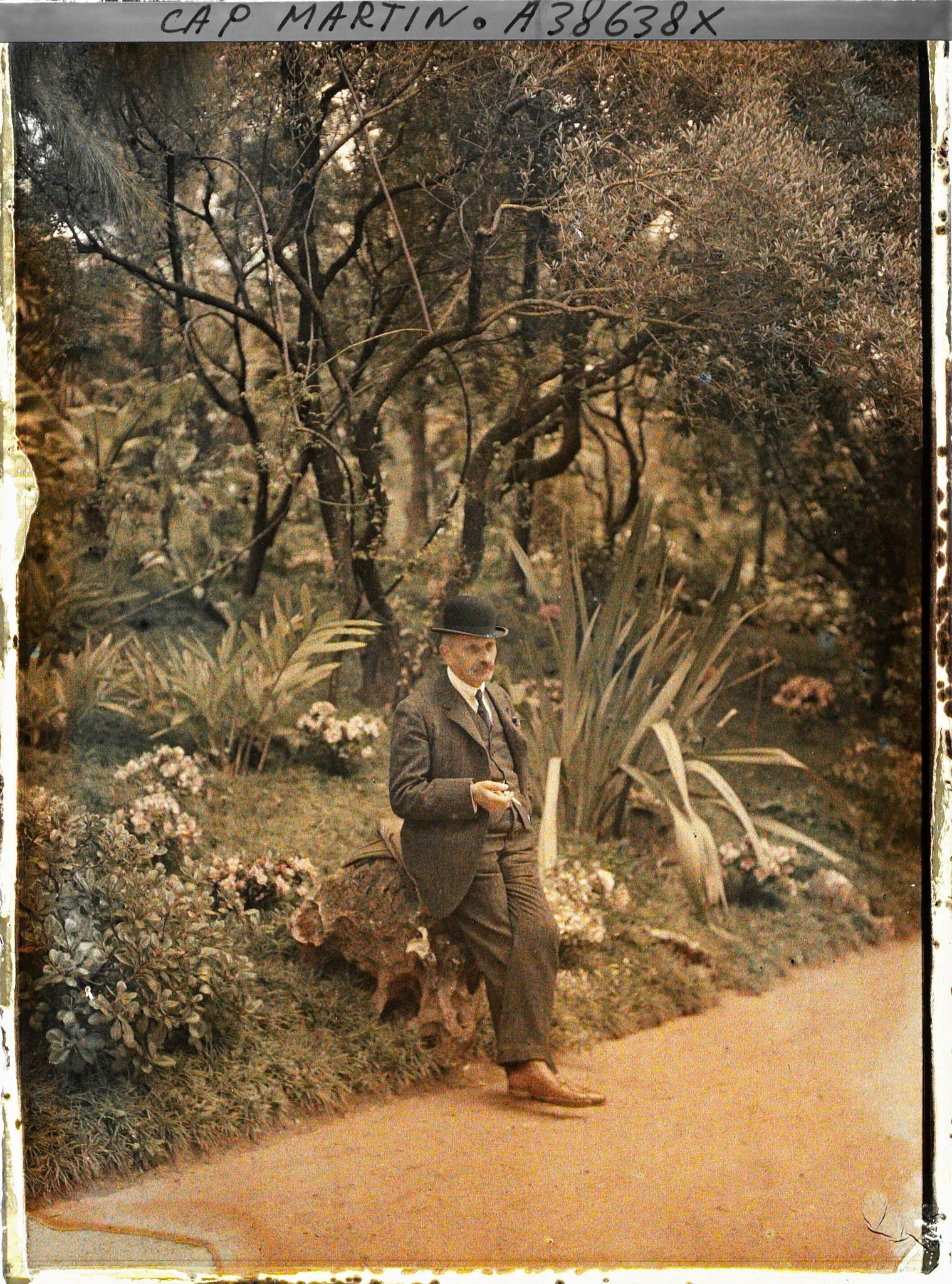 Image représentant "L'aide-chauffeur" (au service d'Albert Kahn ou de ses invités) dans le jardin de la villa