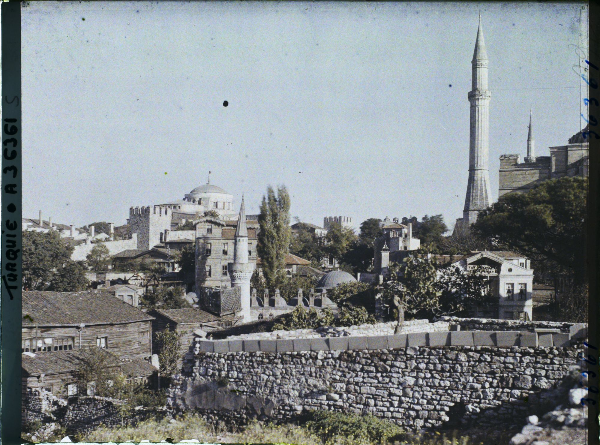 Image représentant Quartier de Aya Sofya Camii ("mosquée Sainte-Sophie") avec au centre, derrière un mur et des maisons, la Cafer Aga (ou Caferaga) Medresesi, à gauche, la coupole de Aya Irini Kilisesi ("église Sainte-Irène") et à droite, un minaret ouest de Aya Sofya Camii ("mosquée Sainte-Sophie")