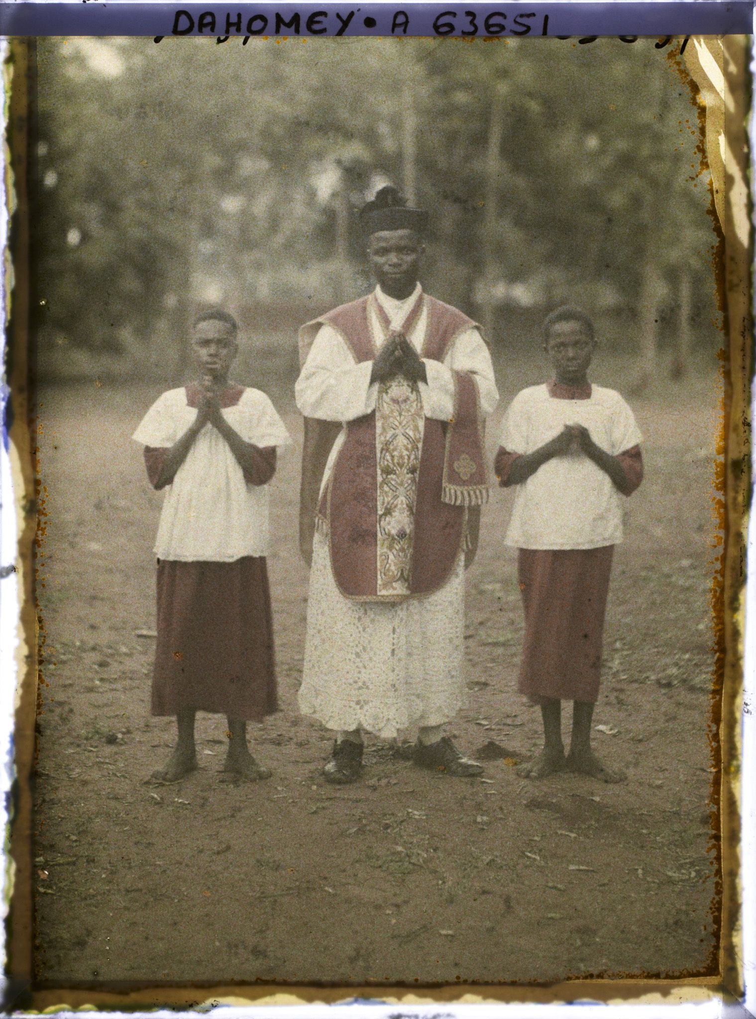 Image représentant L'abbé Gabriel Kiti, premier prêtre dahoméen ordonné par Mgr Steinmetz (le 15 septembre 1929) entouré de deux enfants de chœur