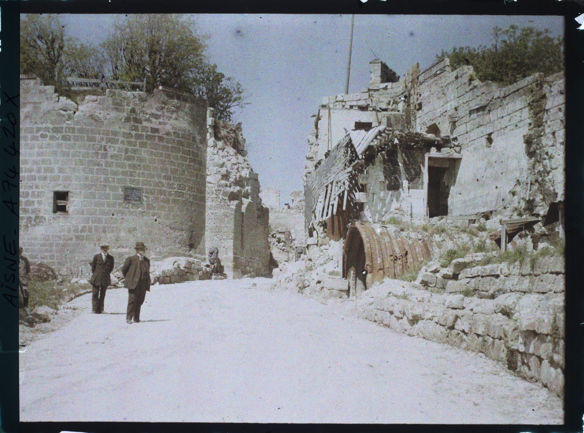 Image représentant A l'intérieur des murs d'enceinte trois hommes prennent la pose devant les restes d'un abris de poilus