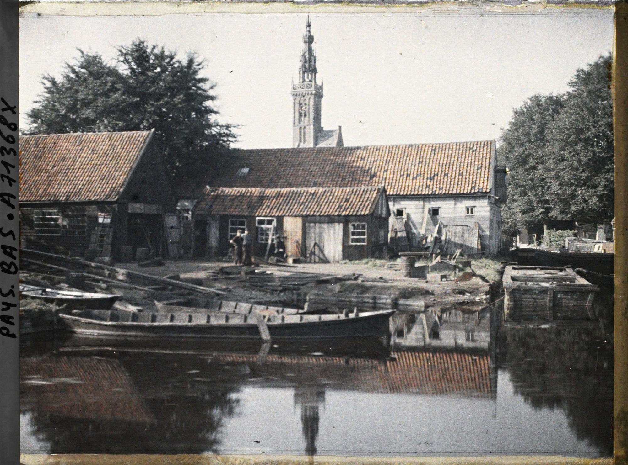 Image représentant Vue d'un canal dans le village, à l'arrière-plan la tour de l'Horloge