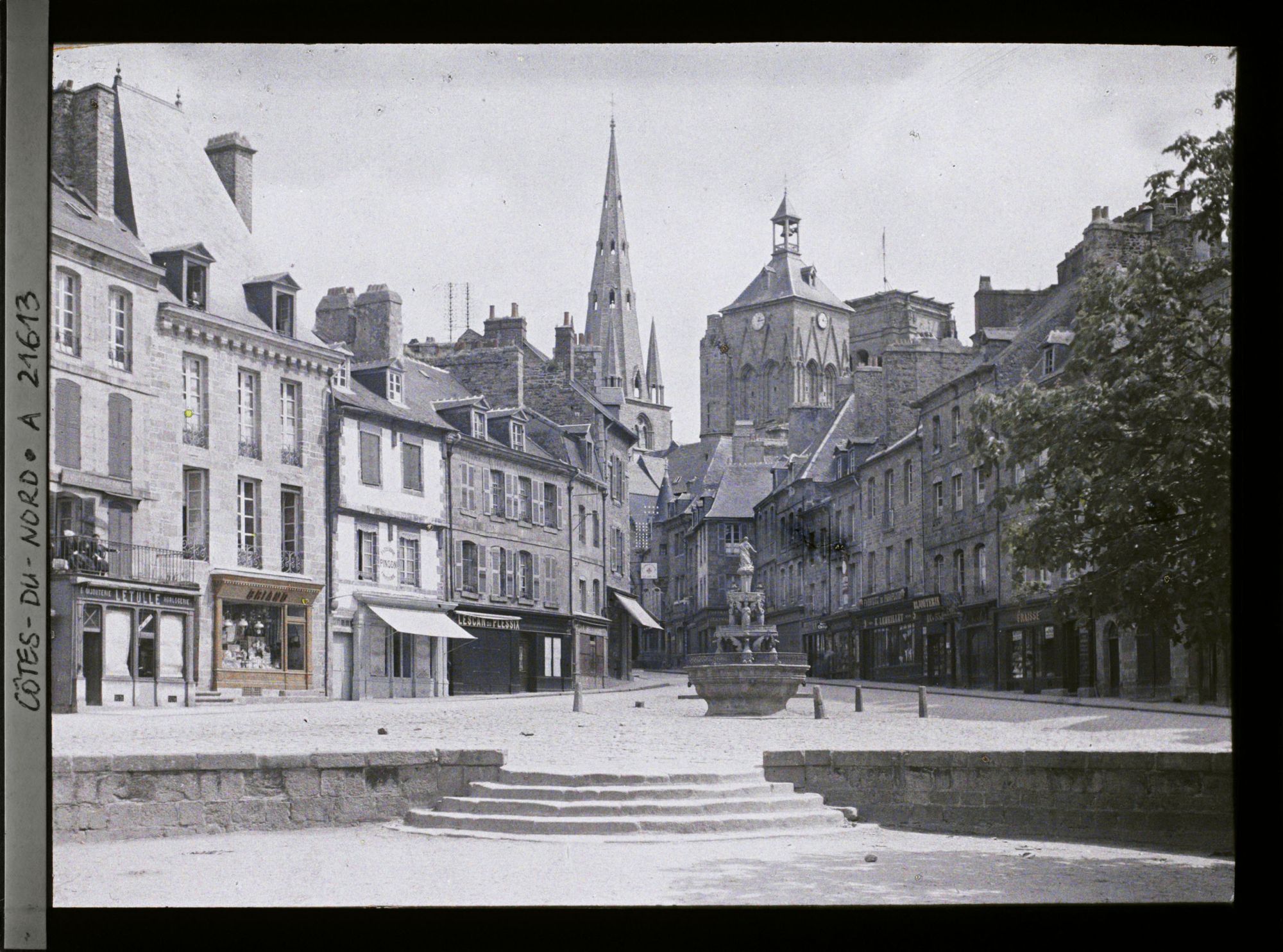 Image représentant La place du Centre avec la fontaine dite "la Plomée" ; à l'arrière-plan, la basilique Notre-Dame-de-Bon-Secours