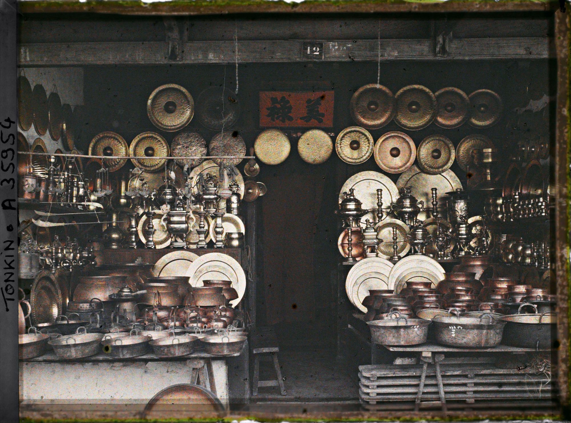 Image représentant Une boutique d'objets en cuivre (ustensiles de cuisine, plateaux...), au numéro 12 de la " rue du Cuivre "