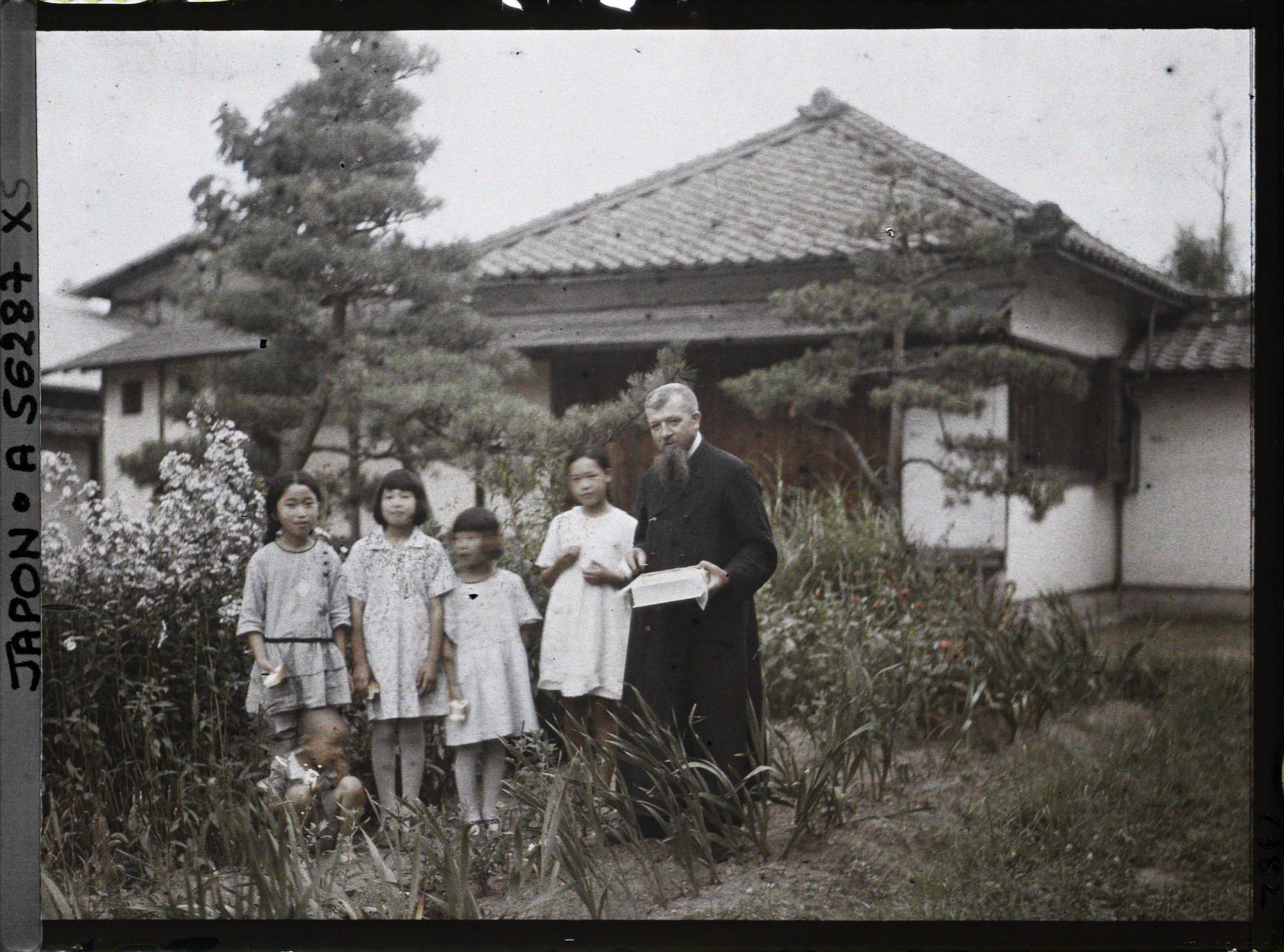 Image représentant Le père Cesselin, missionnaire français, entouré d'un groupe d'enfants vêtus à l'occidentale