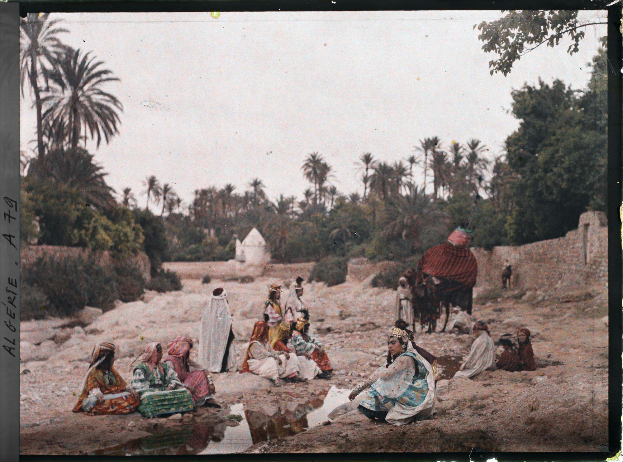 Image représentant Membres de la tribu des Ouled Naïl, assis dans le lit en partie asséché de l'oued Bou Saada, à proximité du pavillon du peintre Dinet