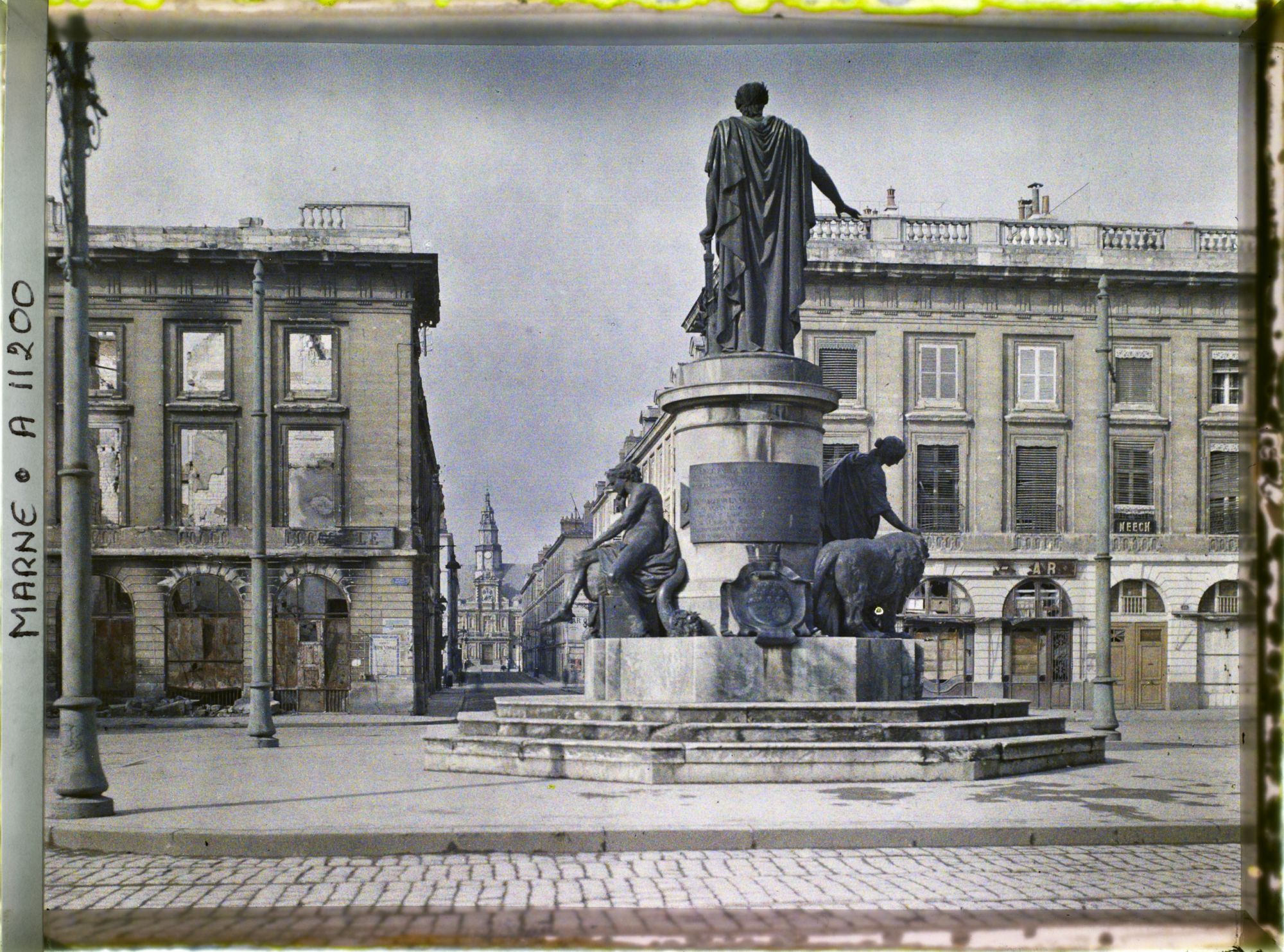 Image représentant La place Royale en ruine avec en son centre la statue de Louis XV et au fond l'Hôtel de ville