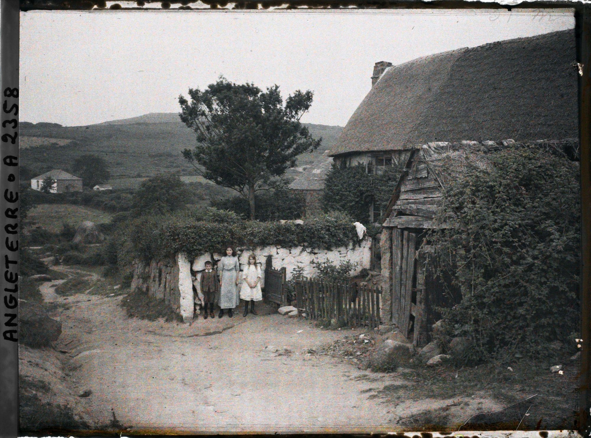 Image représentant Trois enfants posant près d'une maison