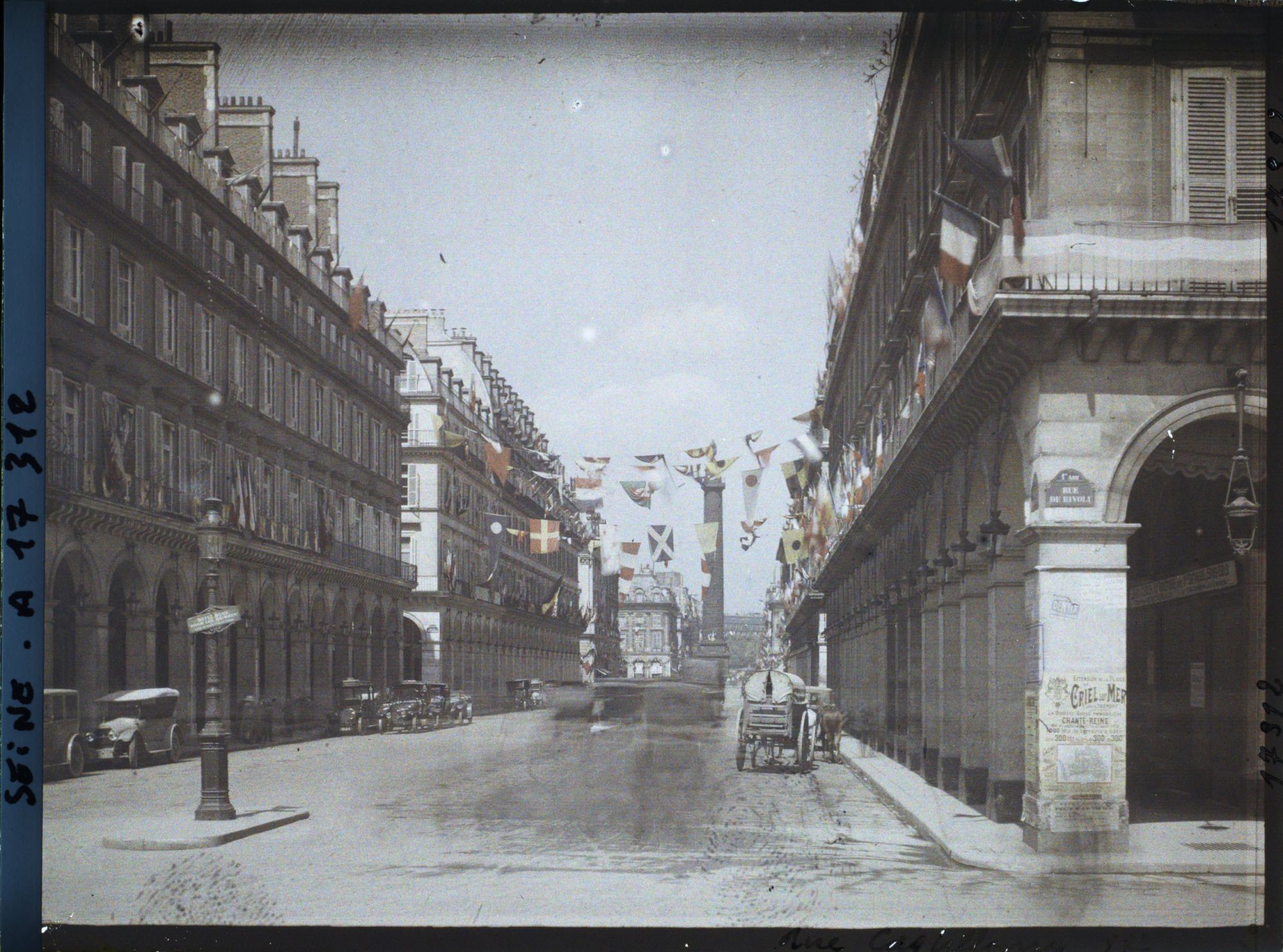 Image représentant La rue Castiglione décorée de drapeaux pour les fêtes de la Victoire des 13 et 14 juillet, vue de la rue de Rivoli