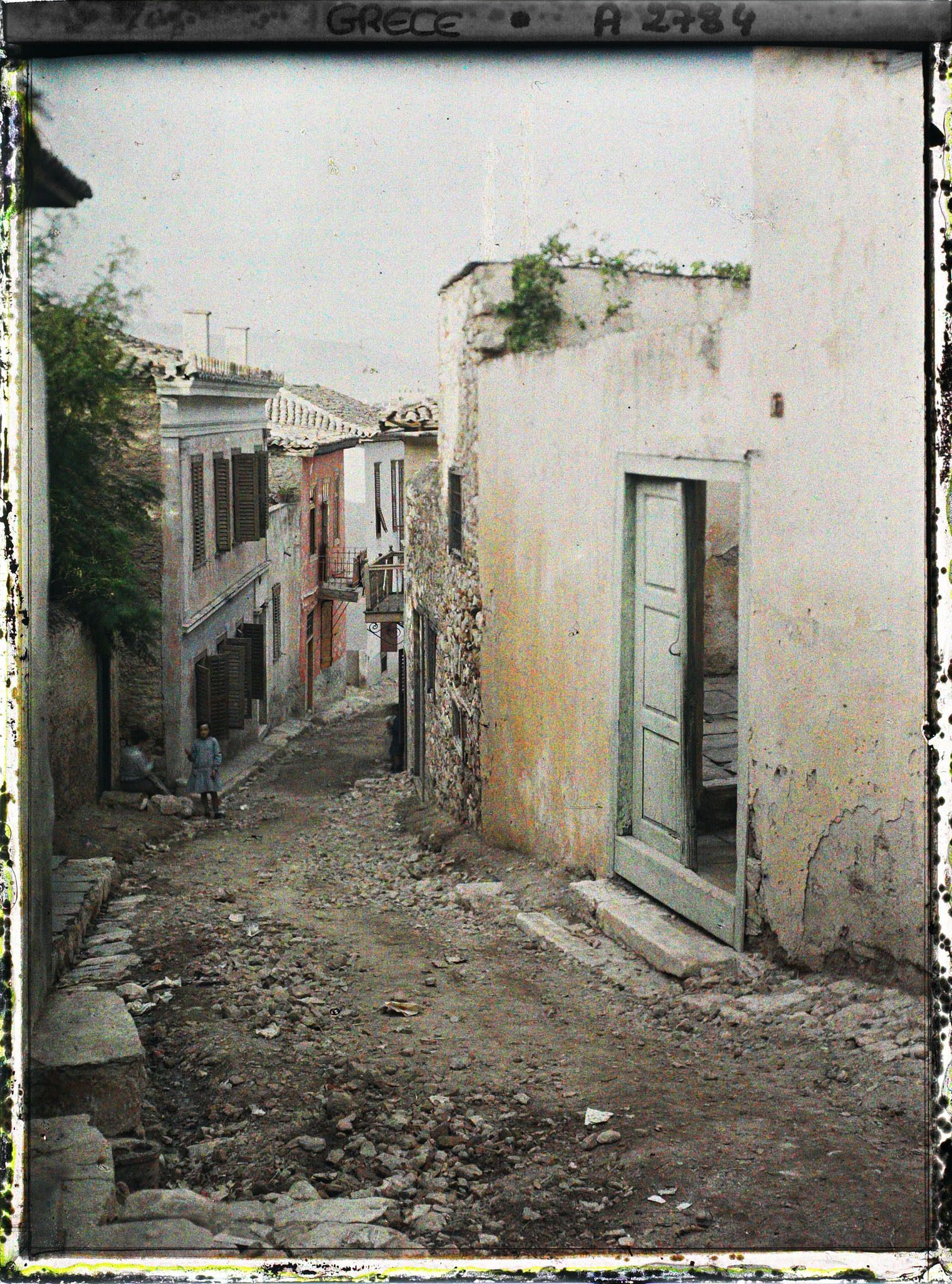 Image représentant Sous l'Acropole, une rue en pente (bordée de maisons)