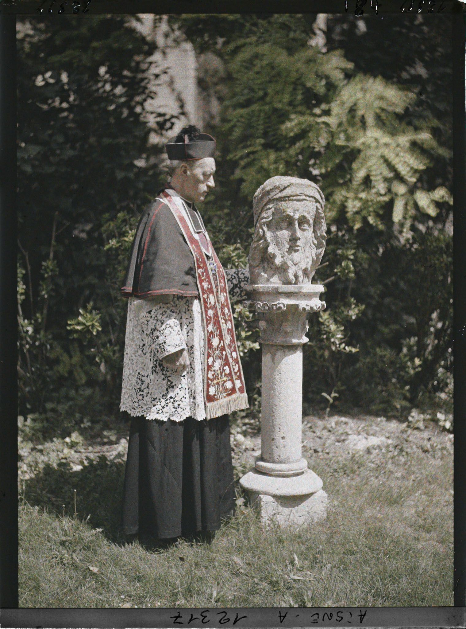 Image représentant Monseigneur Landais, archiprêtre de la cathédrale posant près d'une statue