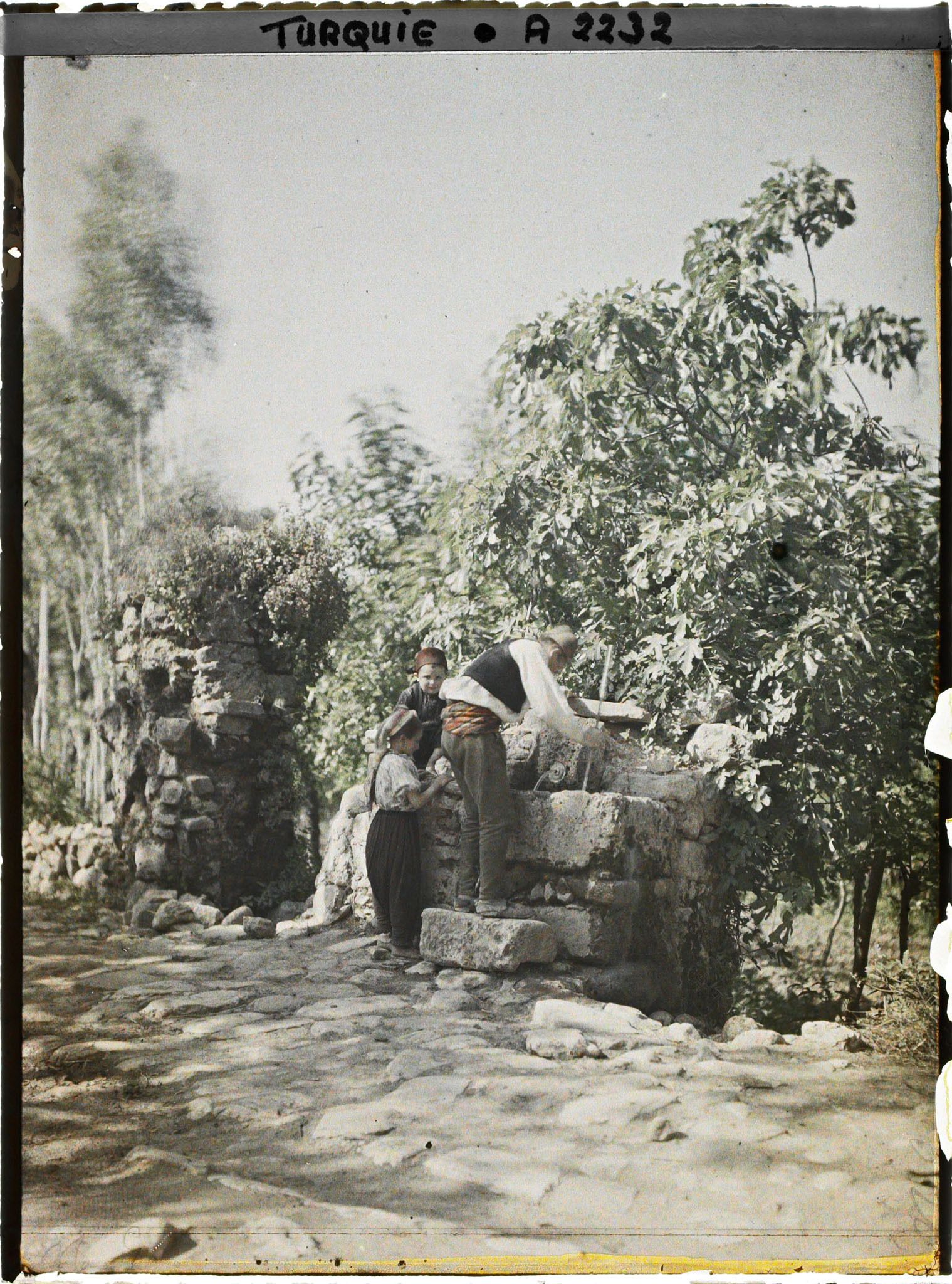Image représentant Un homme et deux enfants à la fontaine