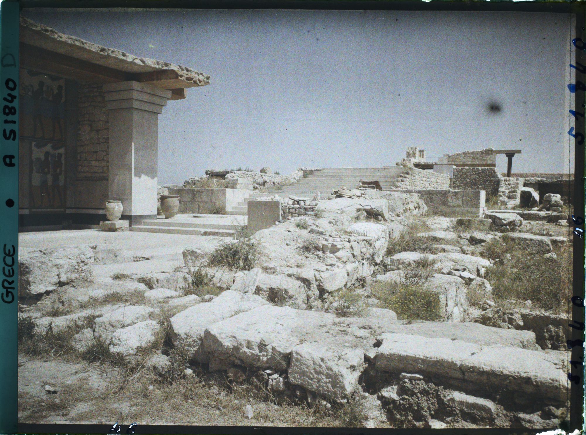 Image représentant Dans le Palais. A gauche, les Propylées sud (entrée du Palais, au bout du couloir de la procession) et au fond, l'escalier d'honneur qui serait aux étages supérieurs de l'aile orientale
