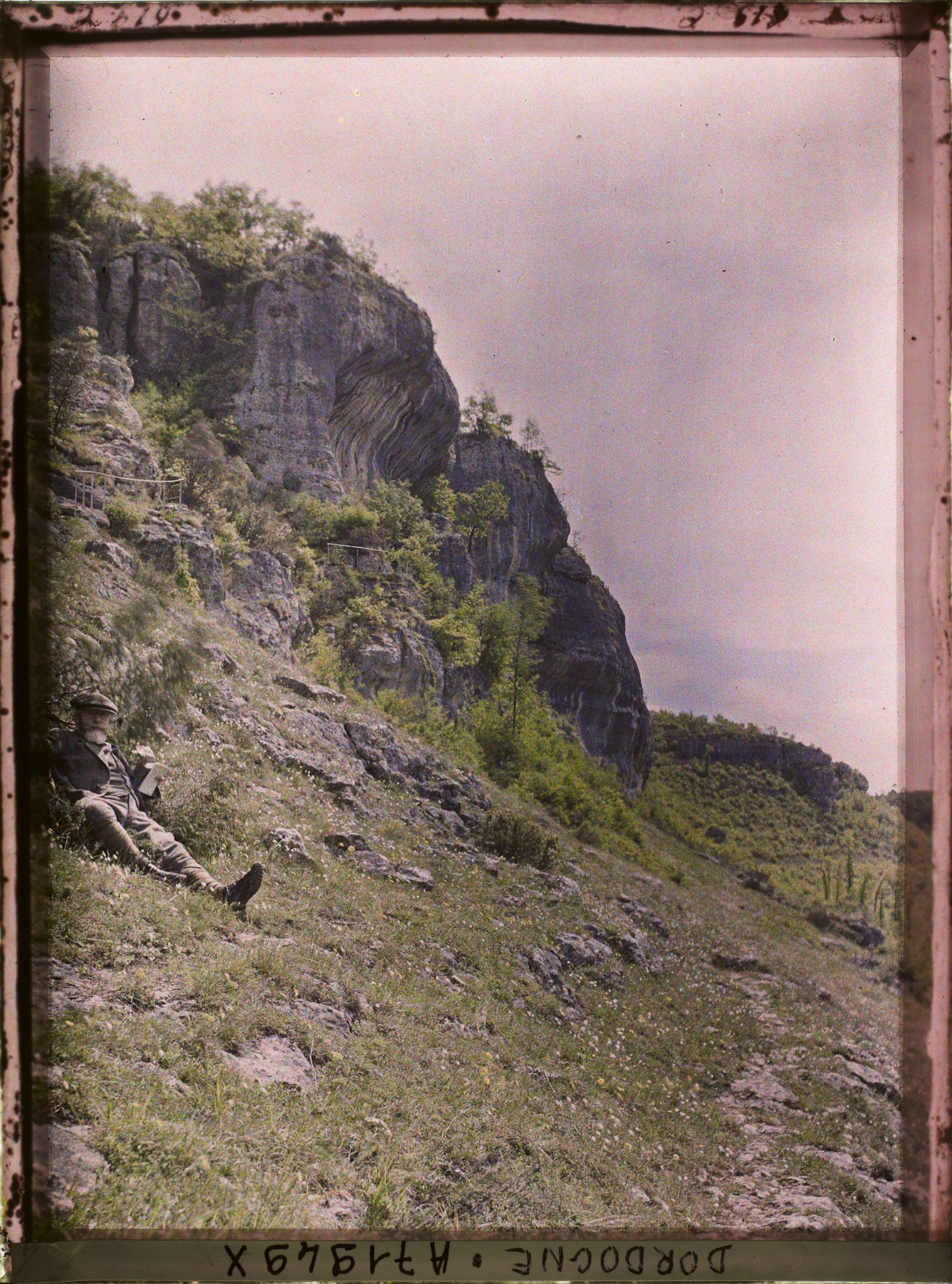 Image représentant Jean Brunhes dans l'herbe près de la grotte de Fond-de-Gaume