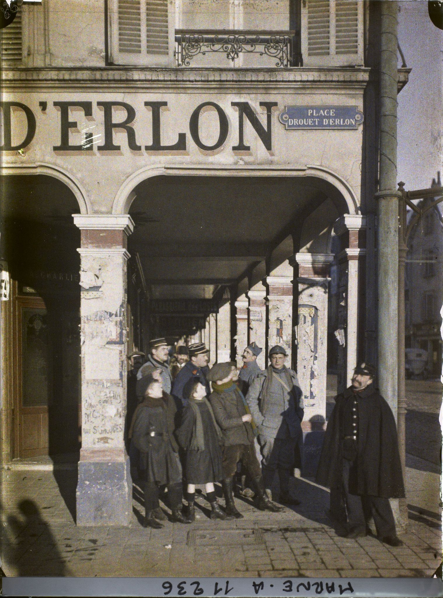Image représentant Soldats et habitants sous les arcades de la place Drouet d'Erlon pendant le passage d'un avion