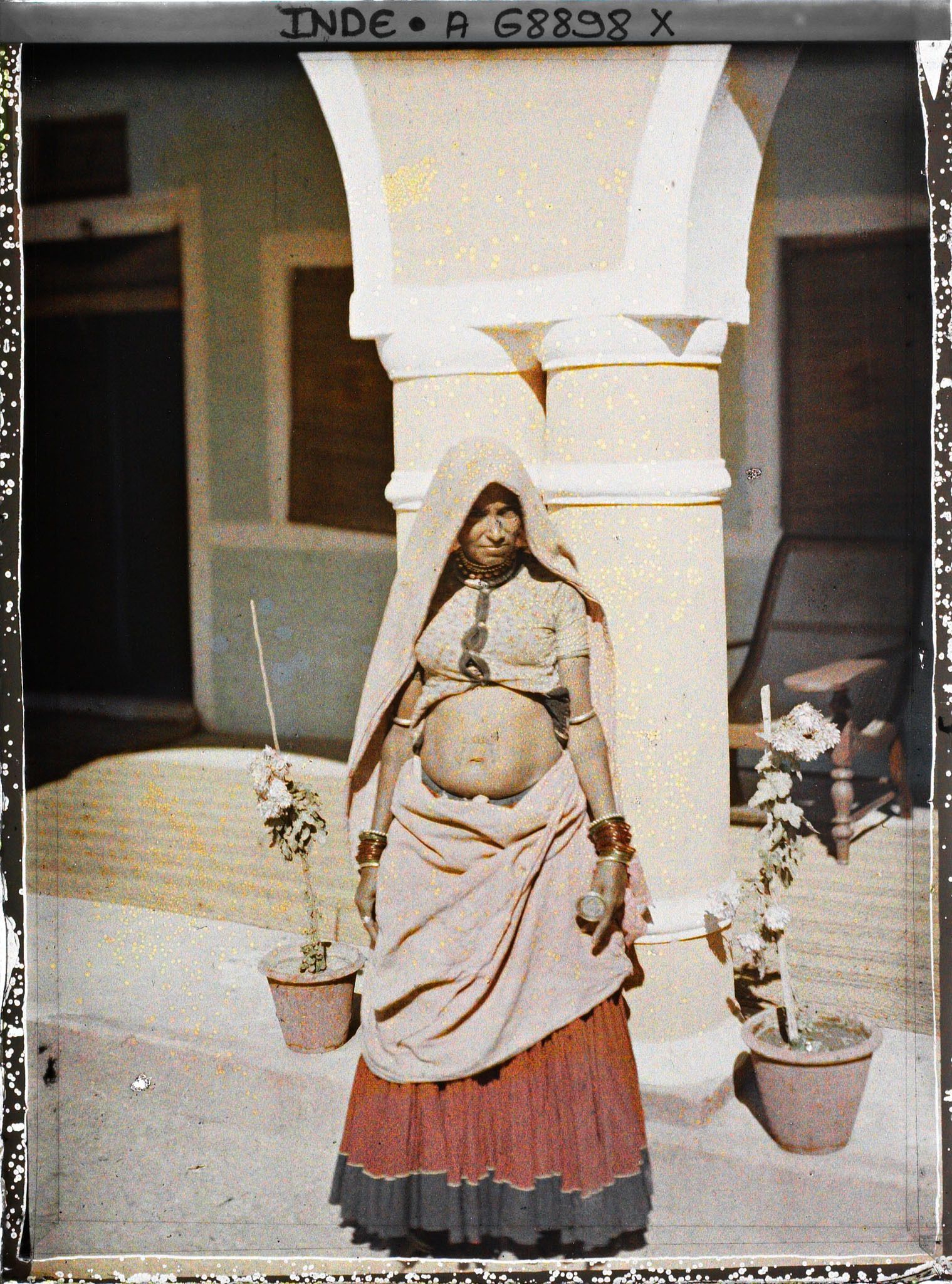 Image représentant Une femme debout à l'entrée d'une maison ou dans une cour intérieure