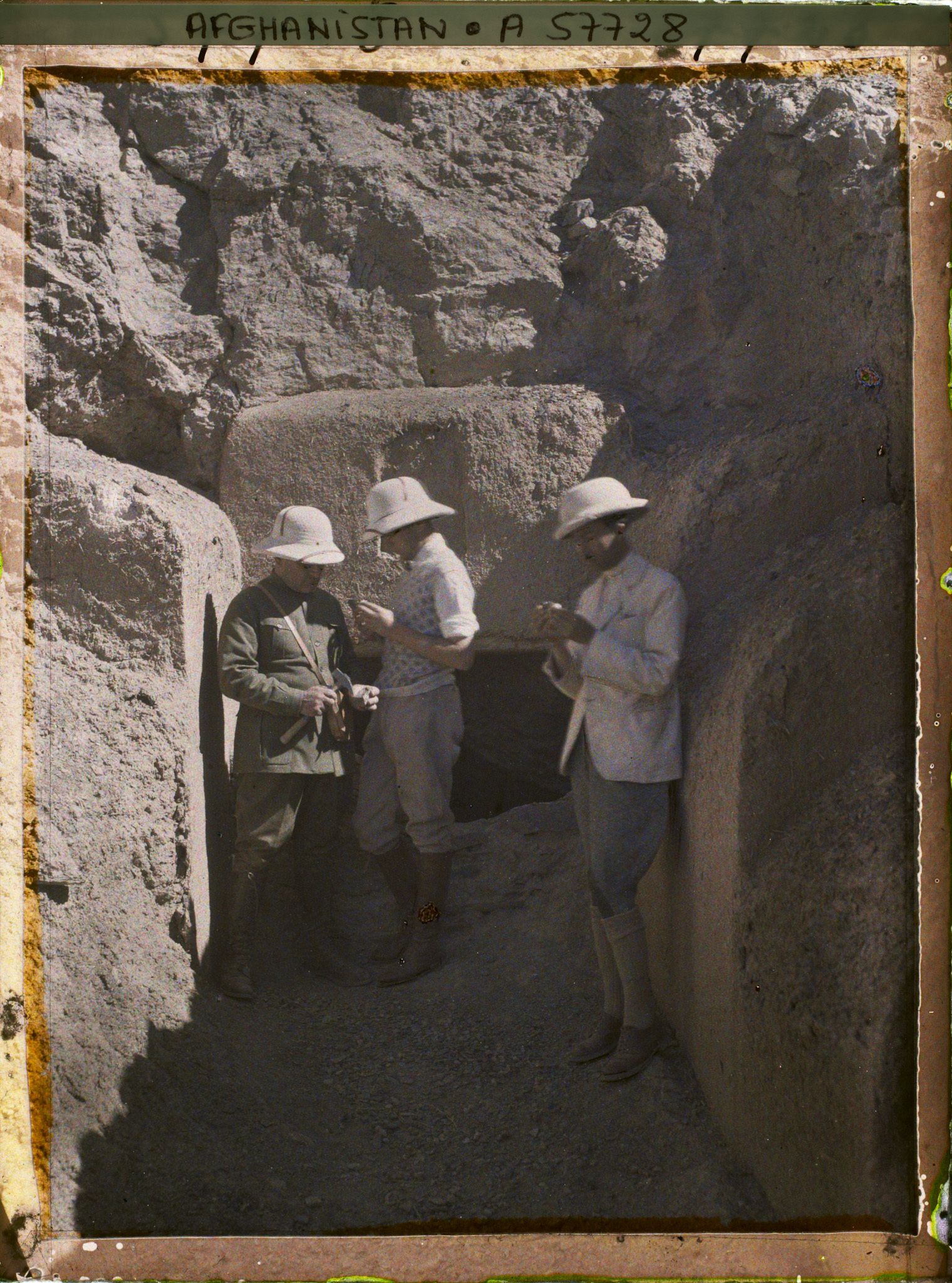 Image représentant Messieurs Th. Makcheff, chef de la "Mission d'Études des Chemins de fer de l'Afghanistan", P. Clemenceau, secrétaire général et un membre afghan de la mission devant l'entrée de la mine de cuivre