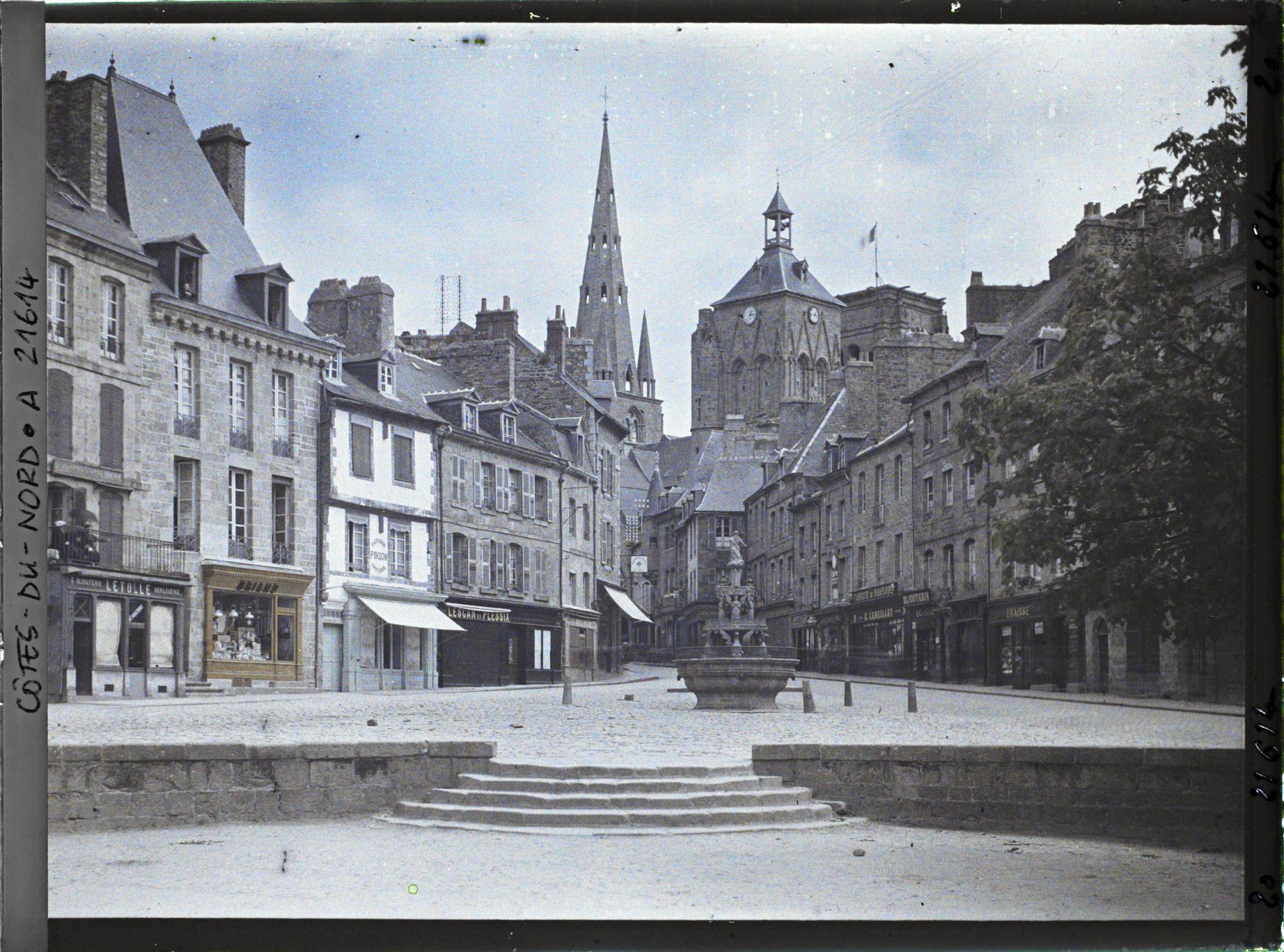 Image représentant La place du Centre avec la fontaine dite "La Plomée" ; à l'arrière-plan, la basilique Notre-Dame-de-Bon-Secours