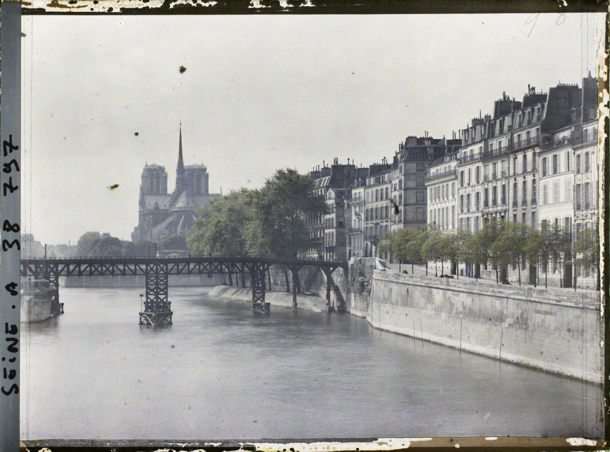 Image représentant Le quai de Béthune, la passerelle provisoire lors de la reconstruction du pont de la Tournelle et la cathédrale Notre-Dame depuis le pont de Sully