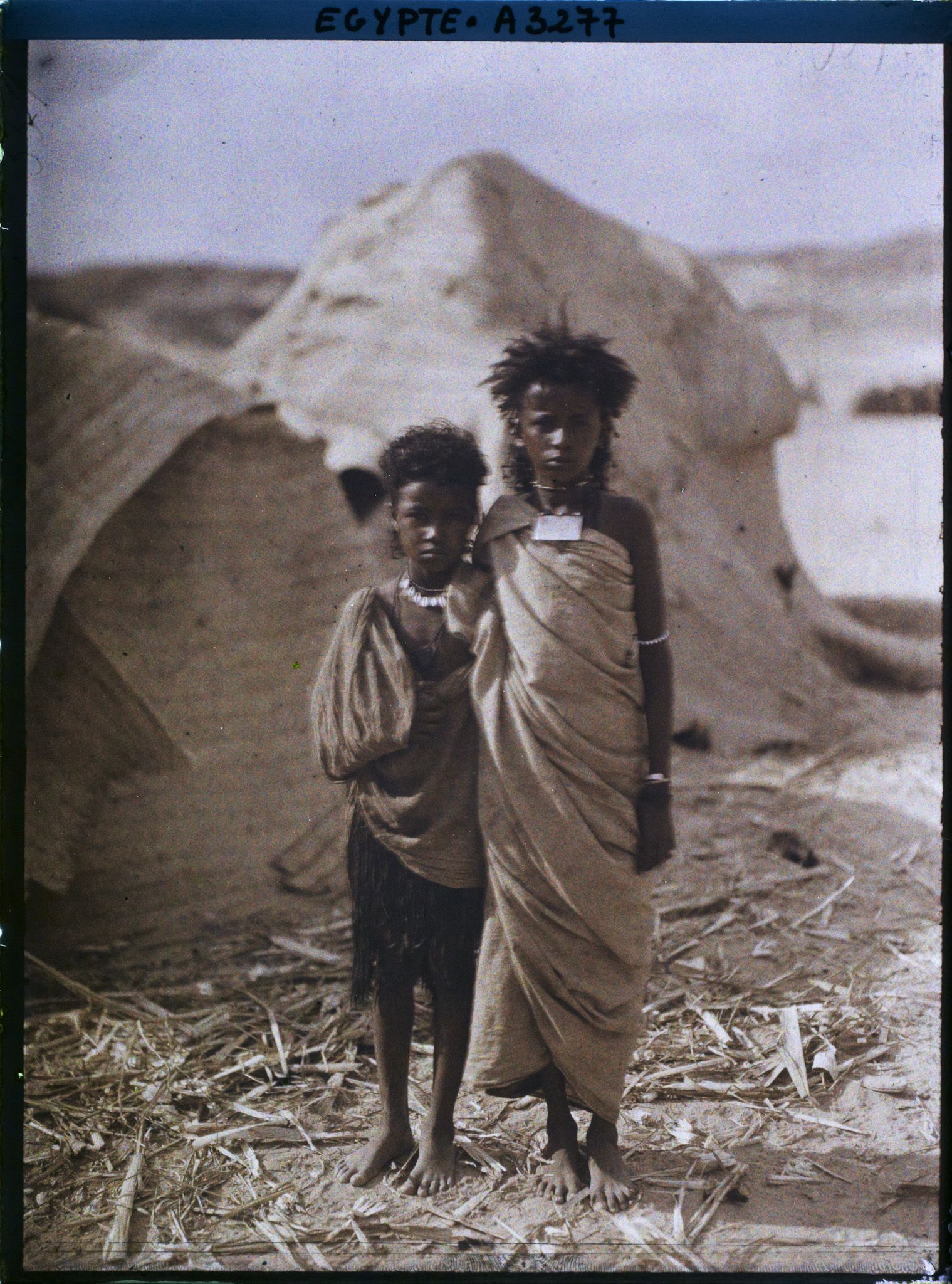 Image représentant Deux enfants  null bishari posent pour l'opérateur devant des habitations