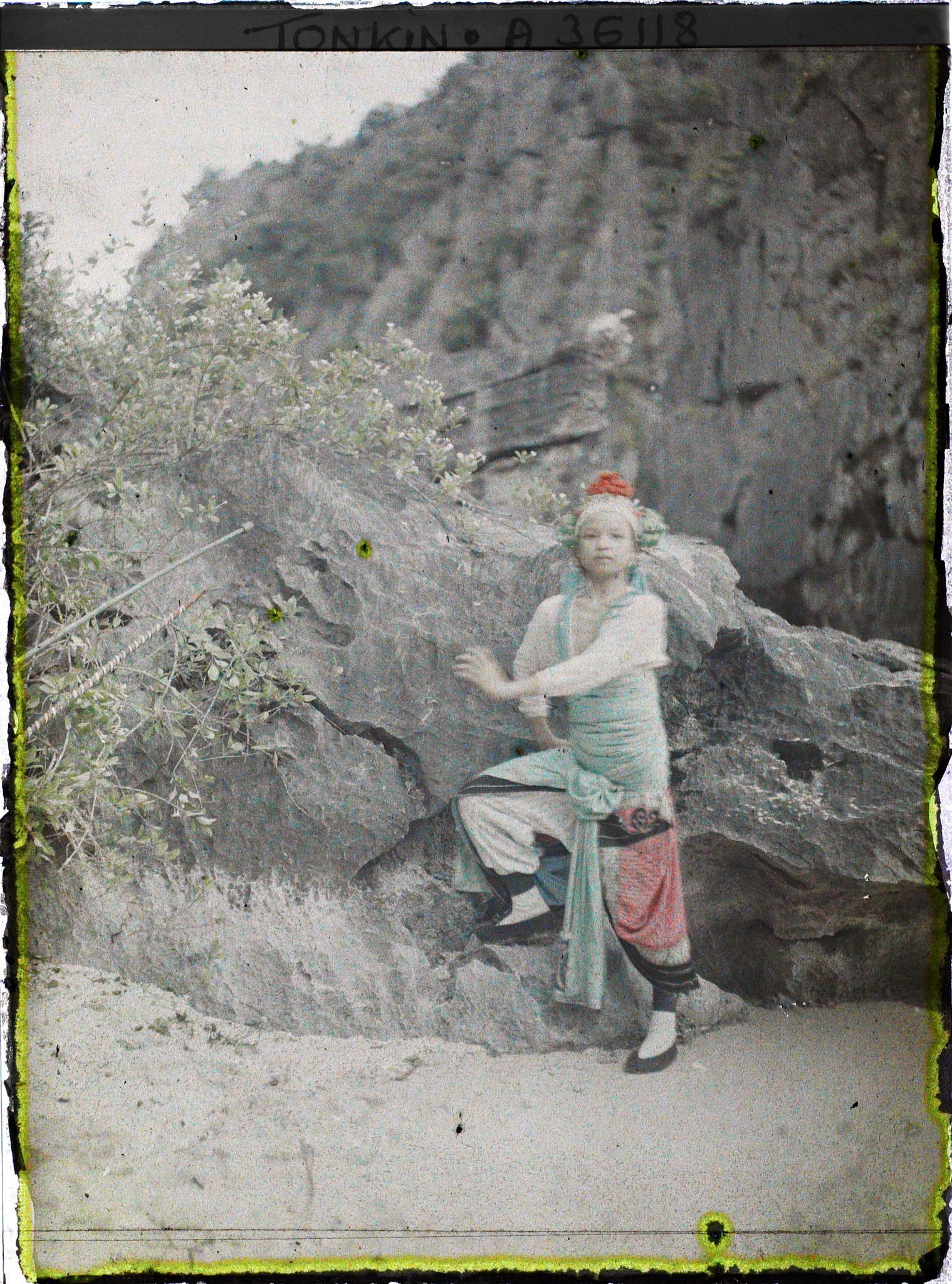 Image représentant Une actrice du Théâtre saïgonnais posant devant un rocher
