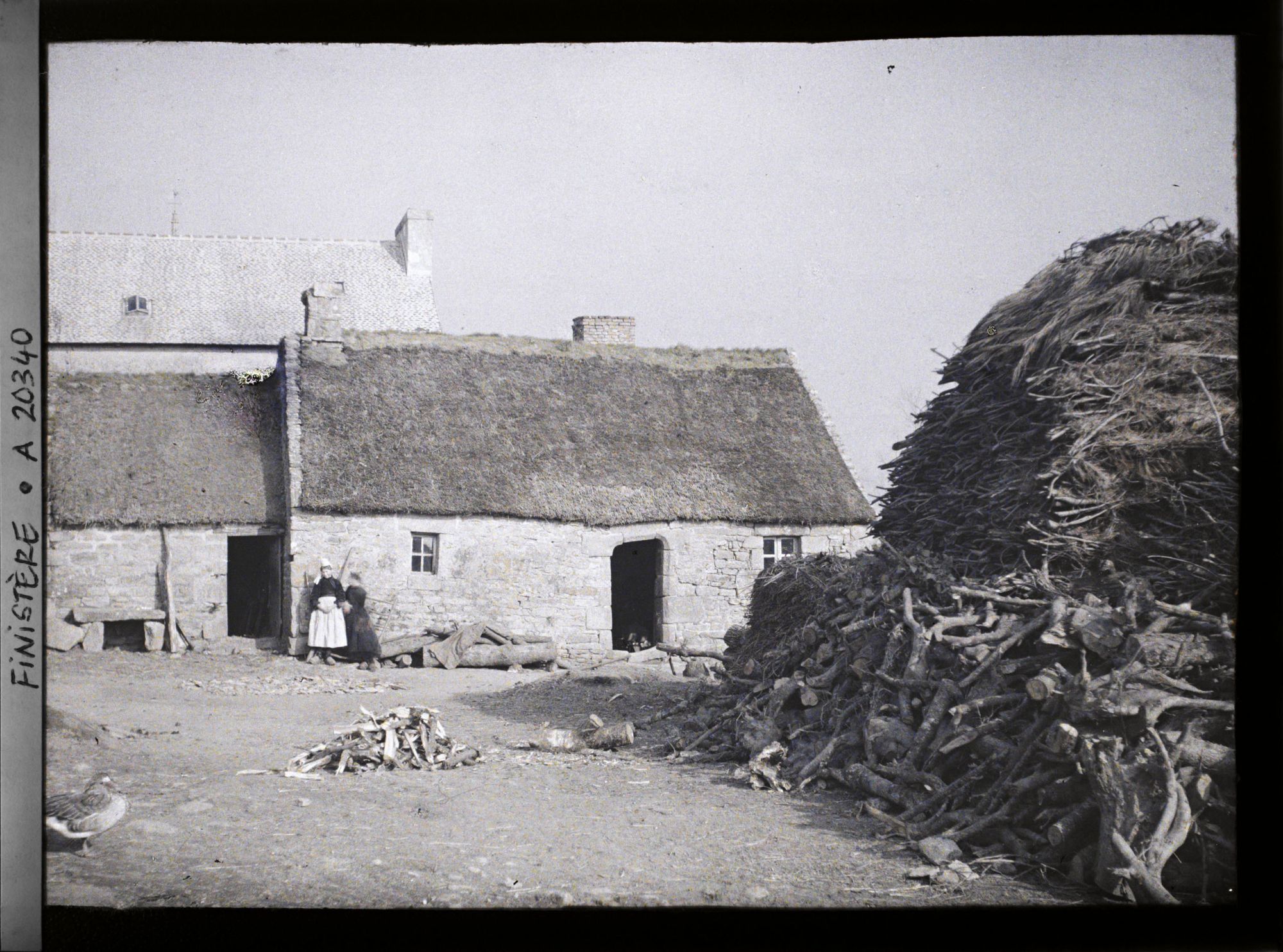 Image représentant Deux femmes devant une ferme à la sortie du village