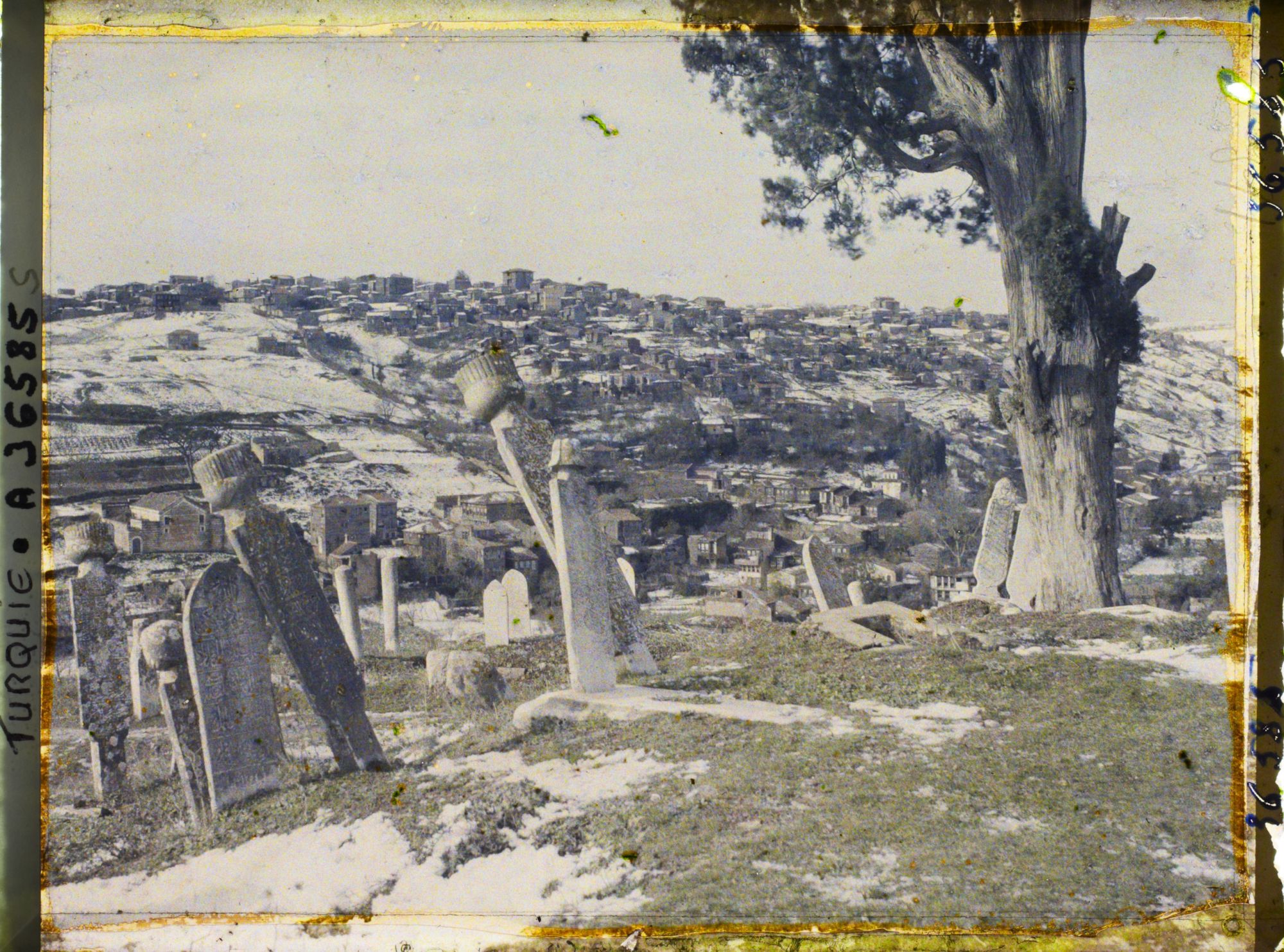 Image représentant Le cimetière d'Eyüp sous la neige avec la colline et ses habitations à l'arrière plan