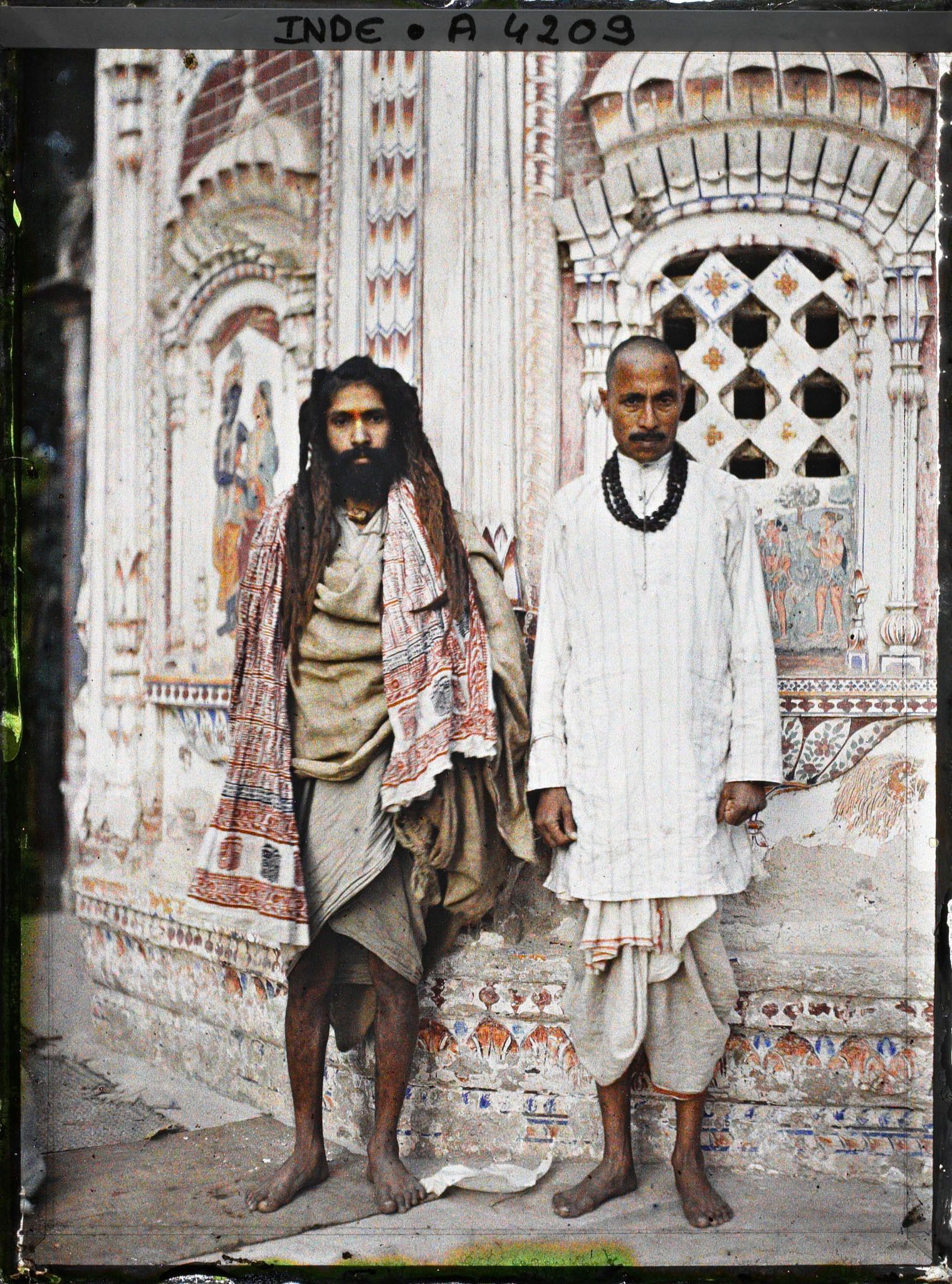Image représentant Brahmane (à droite) et sadhu (à gauche) devant un édicule dans un temple hindou