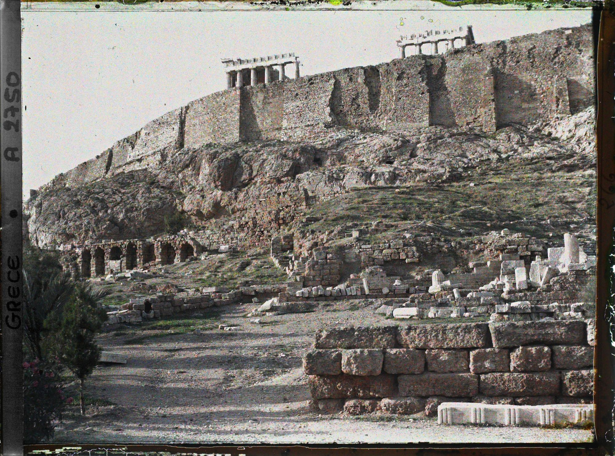 Image représentant A gauche, extrémité du portique d'Eumene qui aboutit à droite du Théâtre de Dyonisos, sous l'Acropole