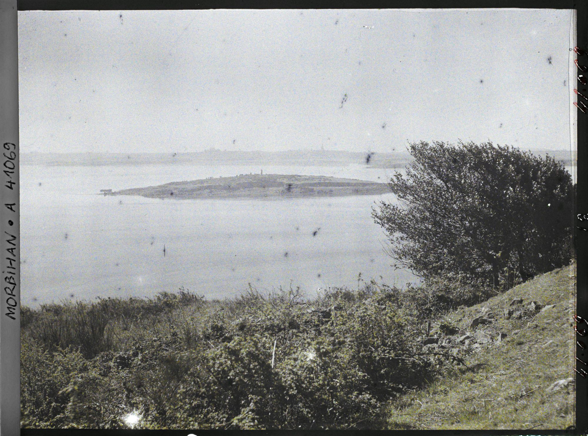 Image représentant L'îlot d'Er Lannic où l'on distingue plusieurs menhirs des cromlechs, vue prise de l'île de Gavrinis