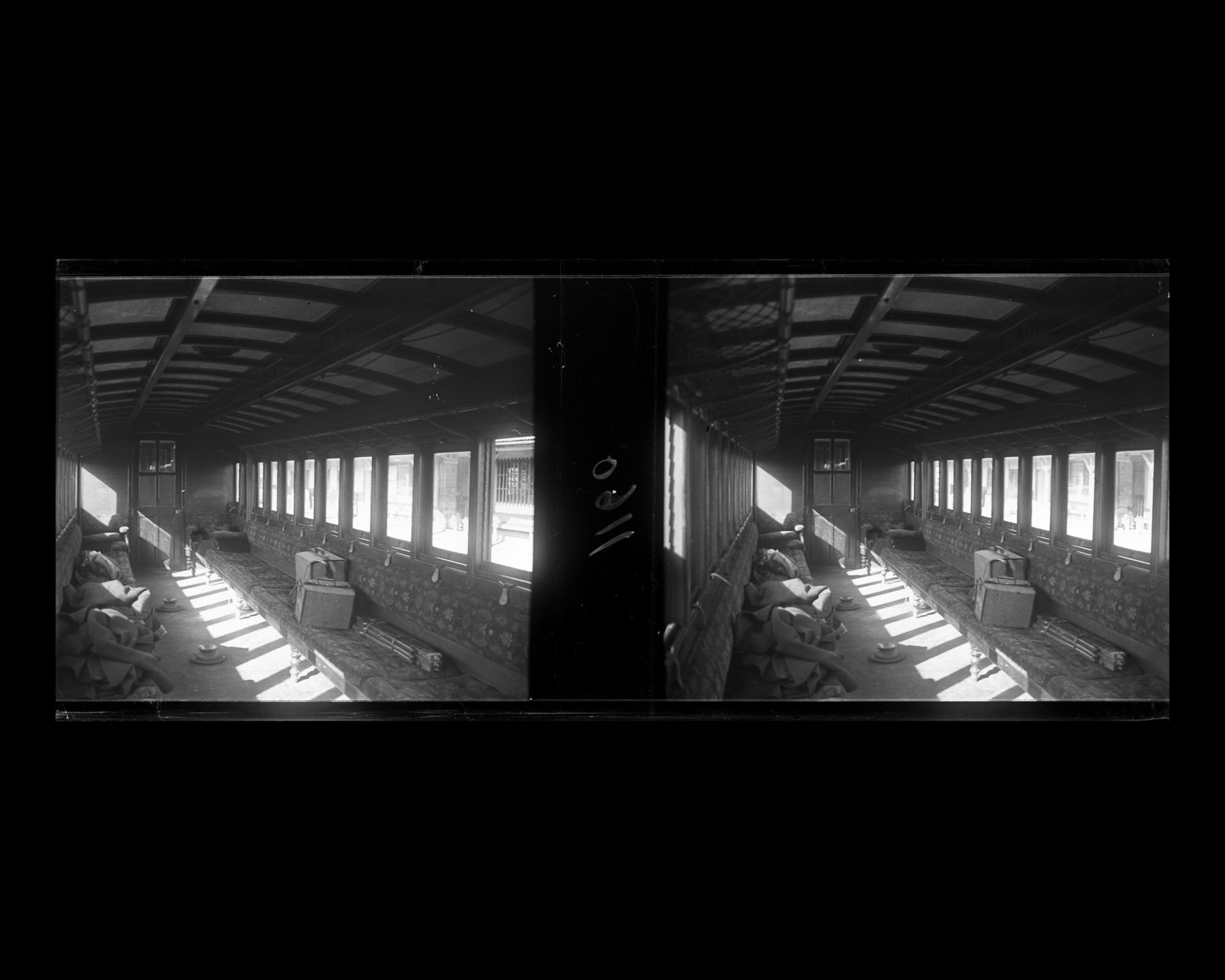 Image représentant Un wagon de 1ere classe, avec sur la banquette le pied et des bagages contenant le matériel de prise de vue