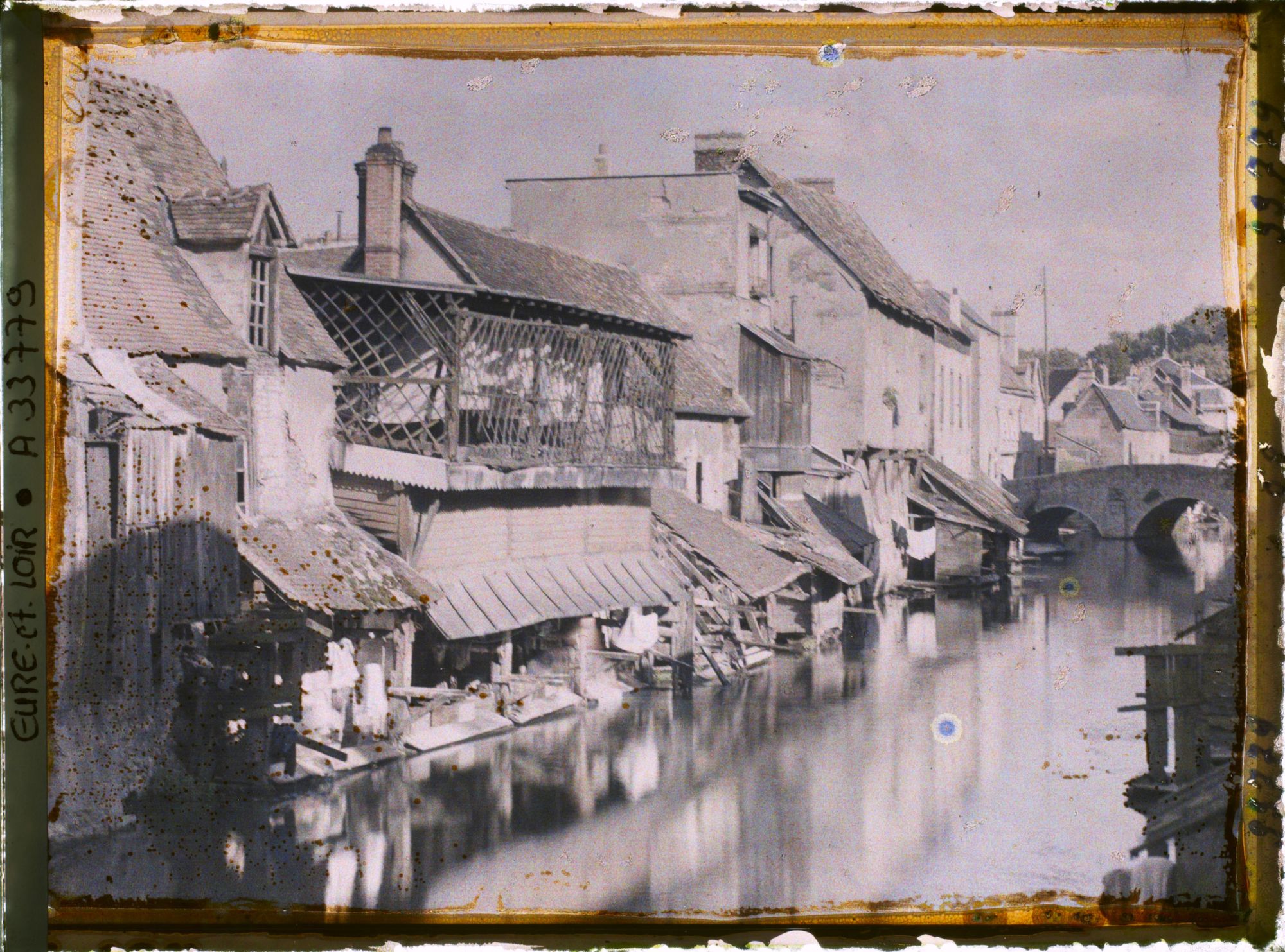 Image représentant Maisons anciennes et lavoirs au bord de l'Eure, au fond le pont Saint-Hilaire