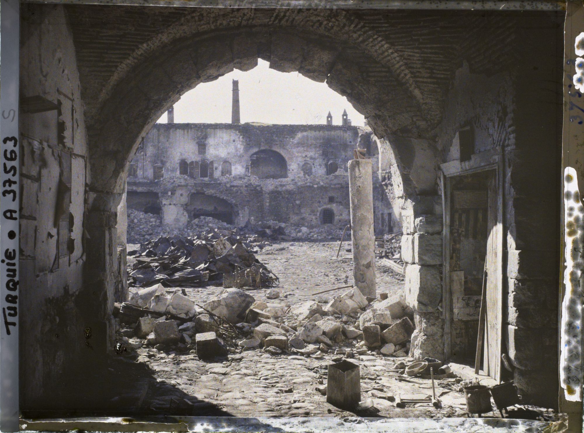 Image représentant Quartier arménien. La cour d'un caravansérail endommagé, à travers un porche, tas de décombres à terre