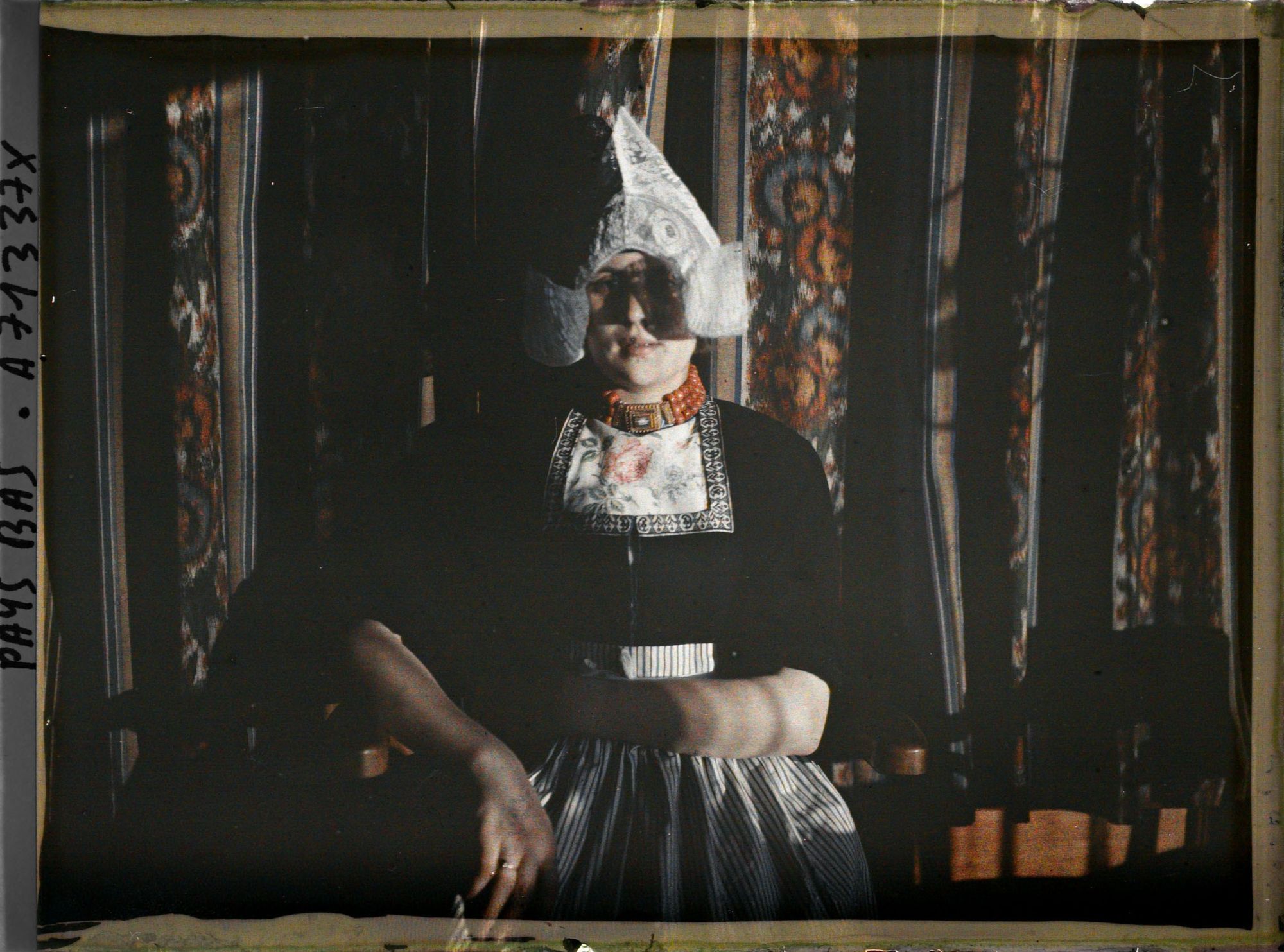 Image représentant Jeune fille (en plan horizontal) devant rideaux rayés à fleurs