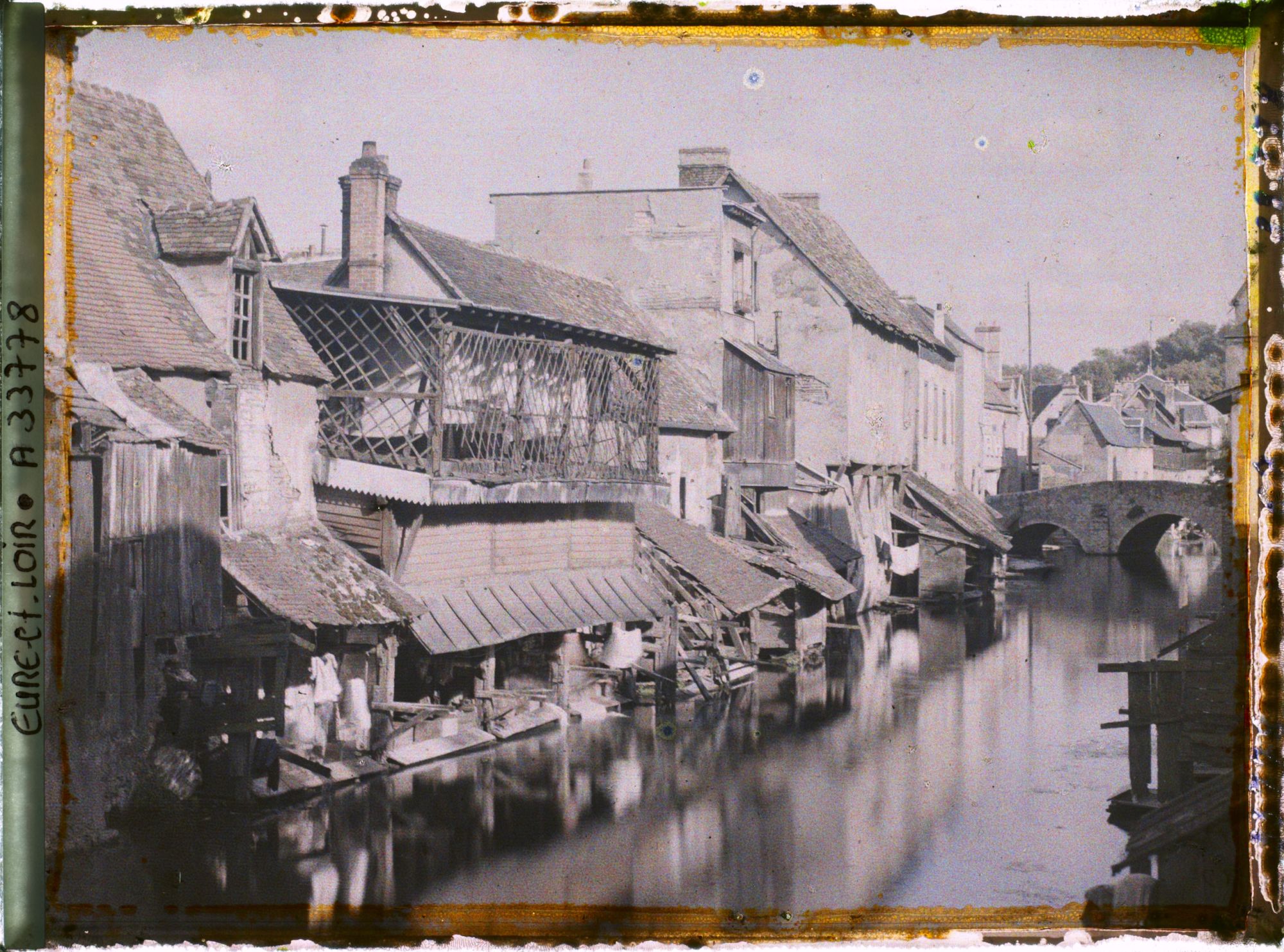 Image représentant Maisons anciennes et lavoirs au bord de l'Eure, au fond le pont Saint-Hilaire