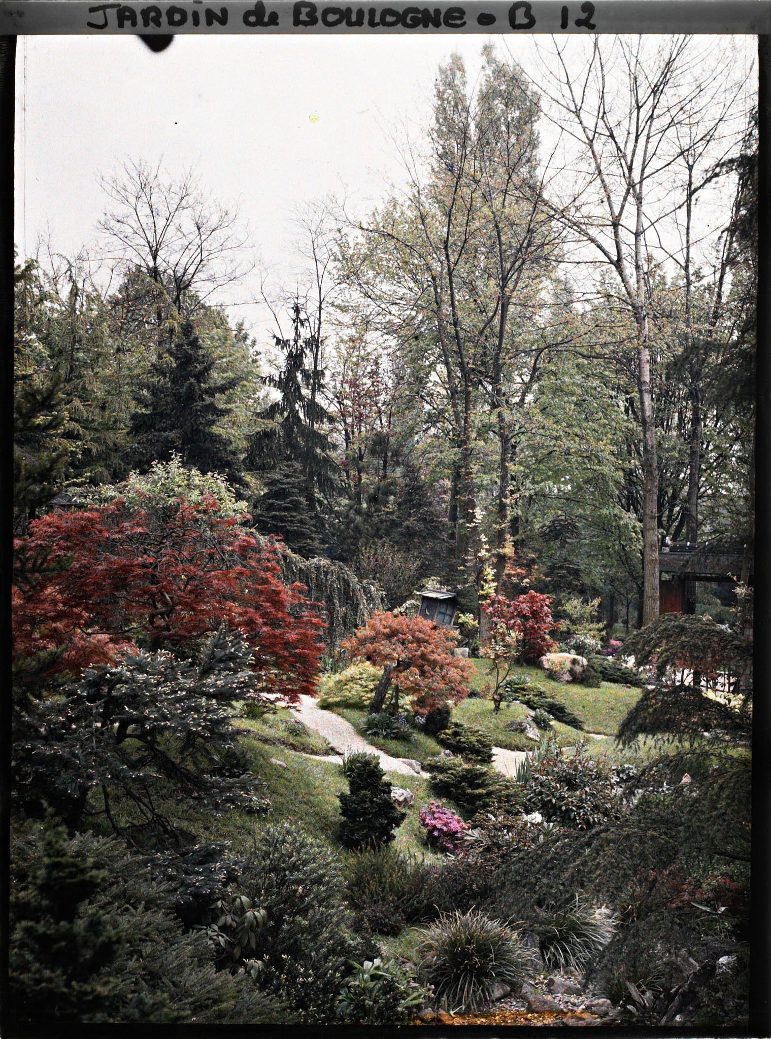 Image représentant Rivière sèche s'étirant au cœur du " village japonais " vers la porte ouvrant sur le jardin anglais