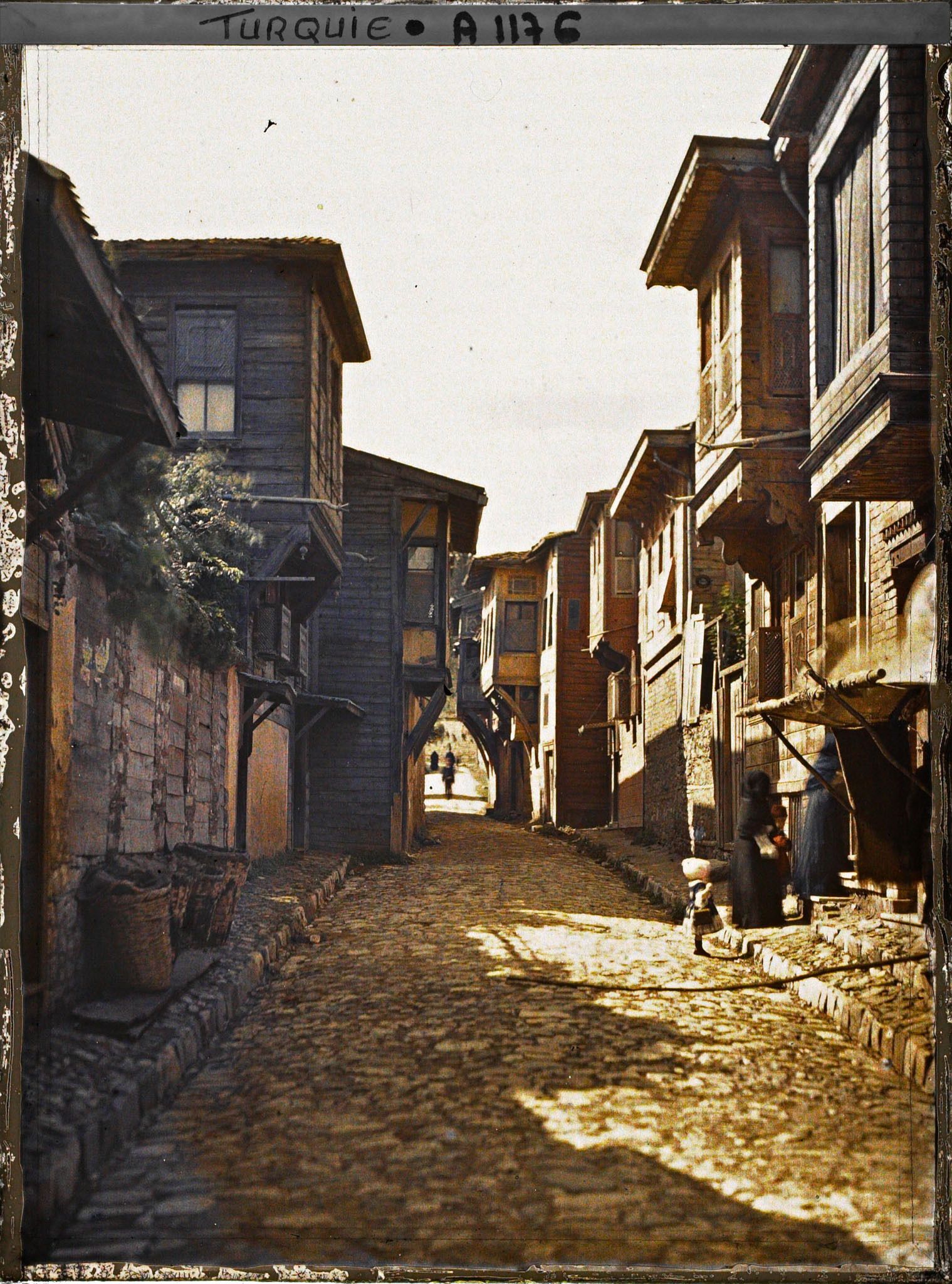 Image représentant Une rue pavée d'Eyüp bordée de maisons en bois à étages saillants