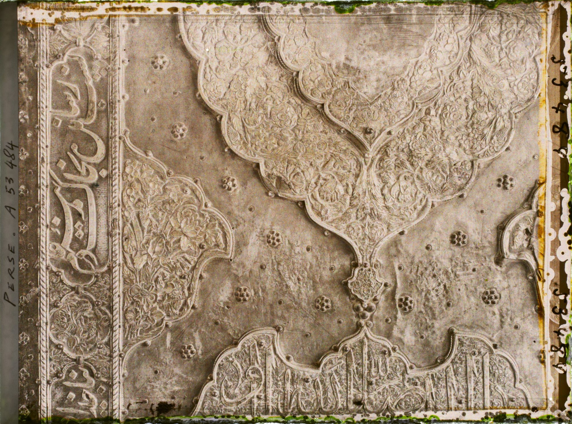 Image représentant La Madreseh Mader-i-Chah, école coranique dite "de la mère du Chah", détail d'une porte en bois recouvert d'argent